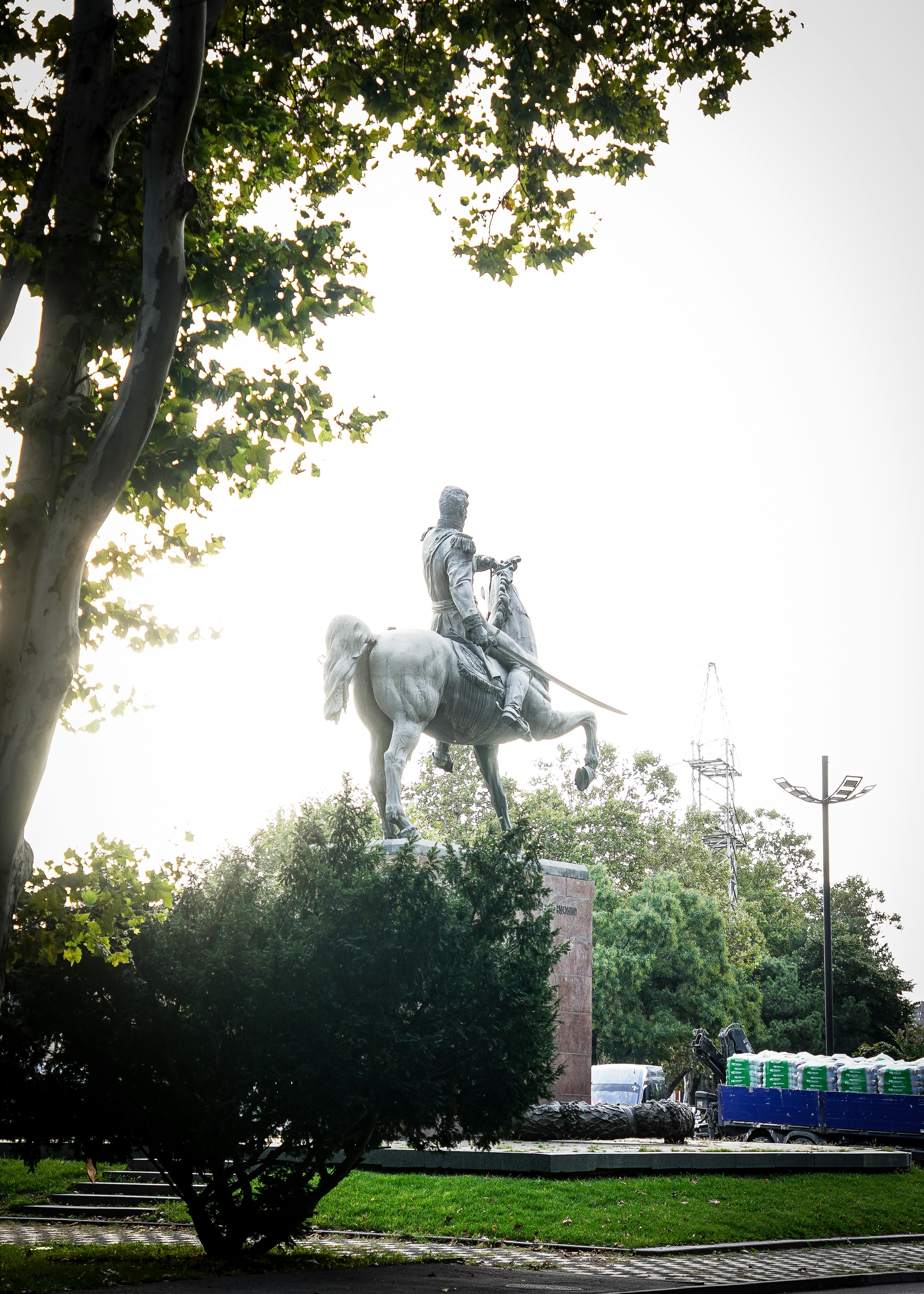 An equestrian statue of a military figure on a stone pedestal in a park