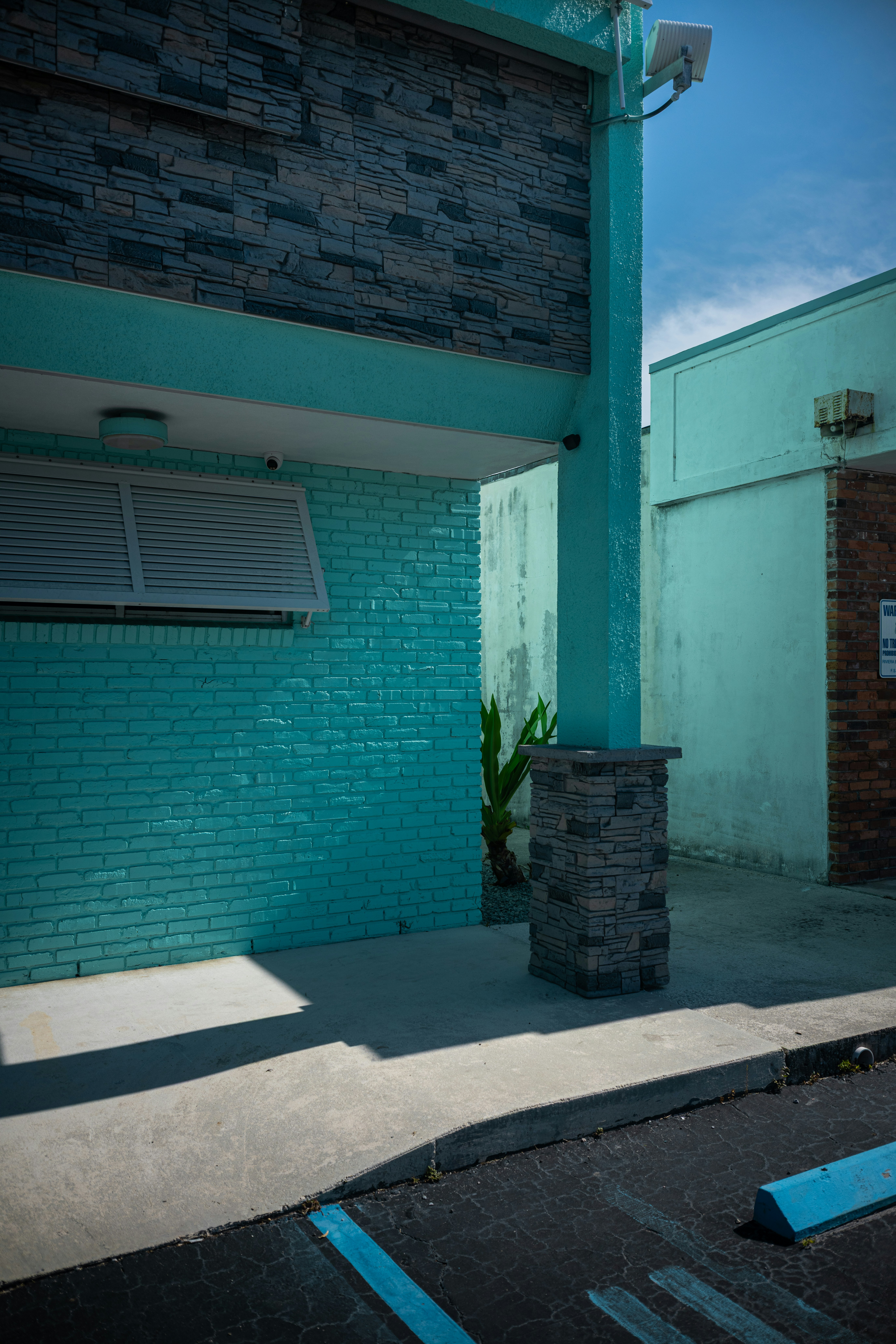 Turquoise brick building with stone pillar - Free Photo on Unsplash
