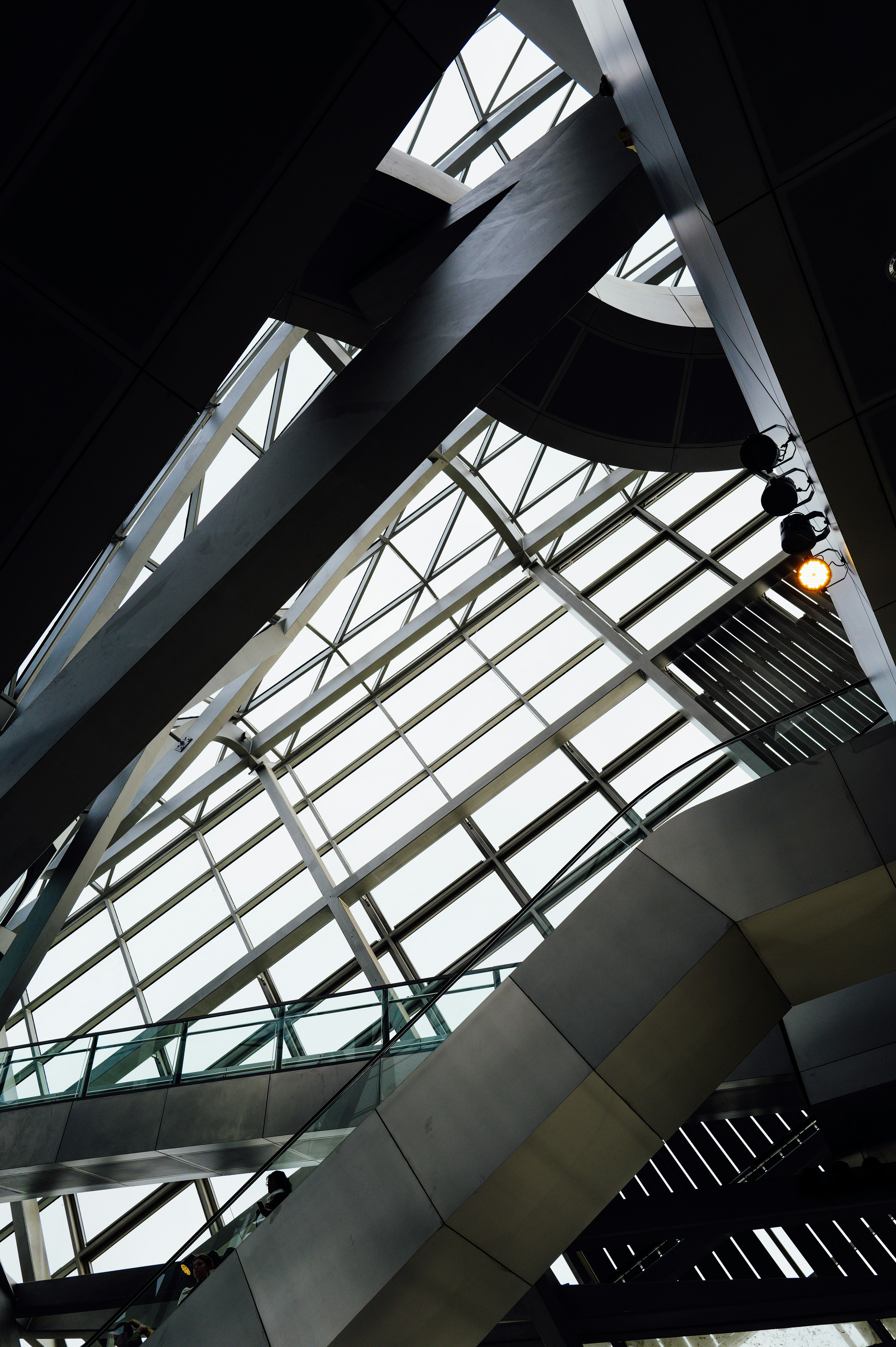 Vue basse d’un plafond moderne en verre avec des poutres en acier et un escalator