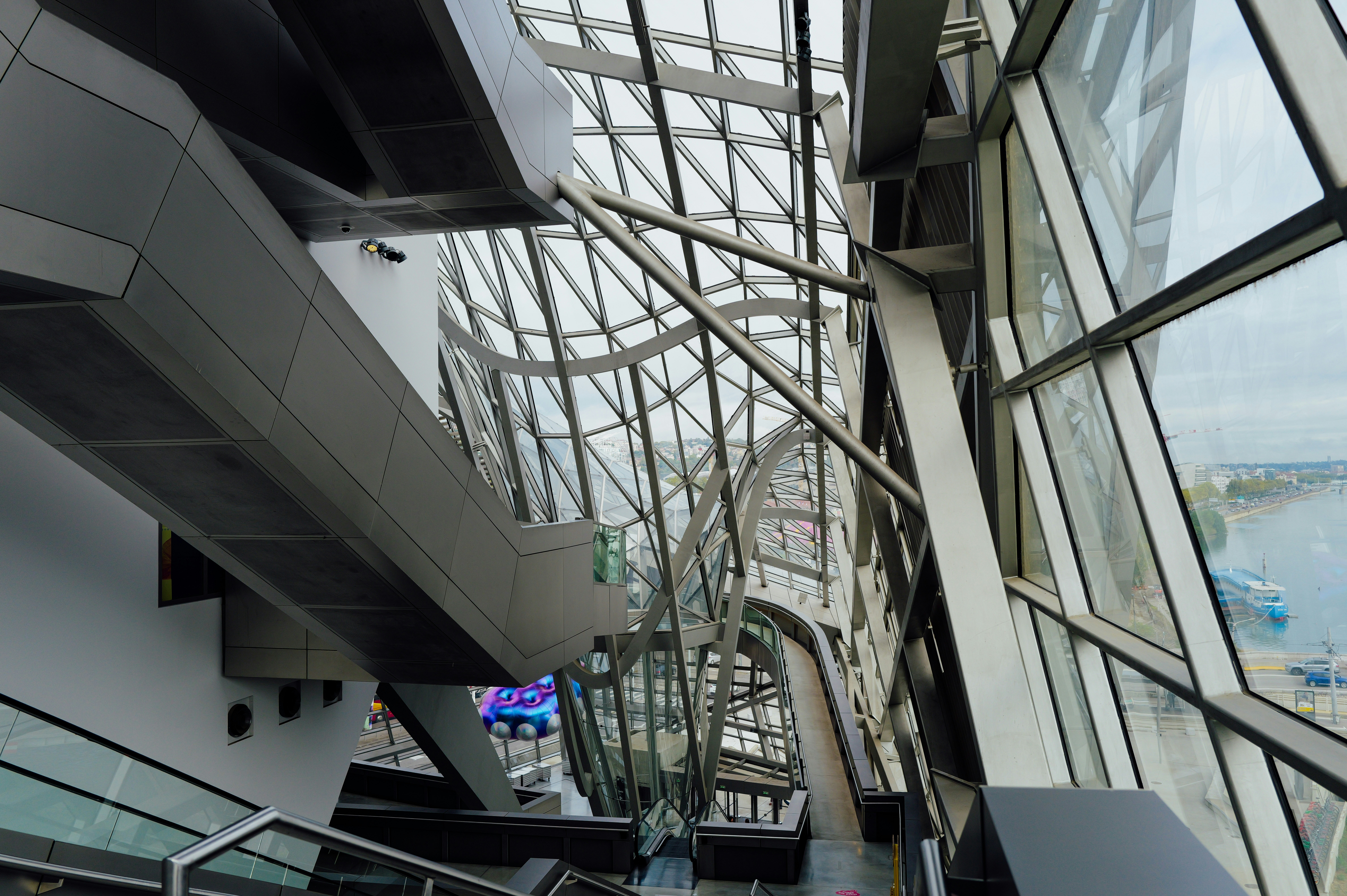 Un intérieur moderne avec une structure complexe en acier et de grandes fenêtres en verre donnant sur une rivière