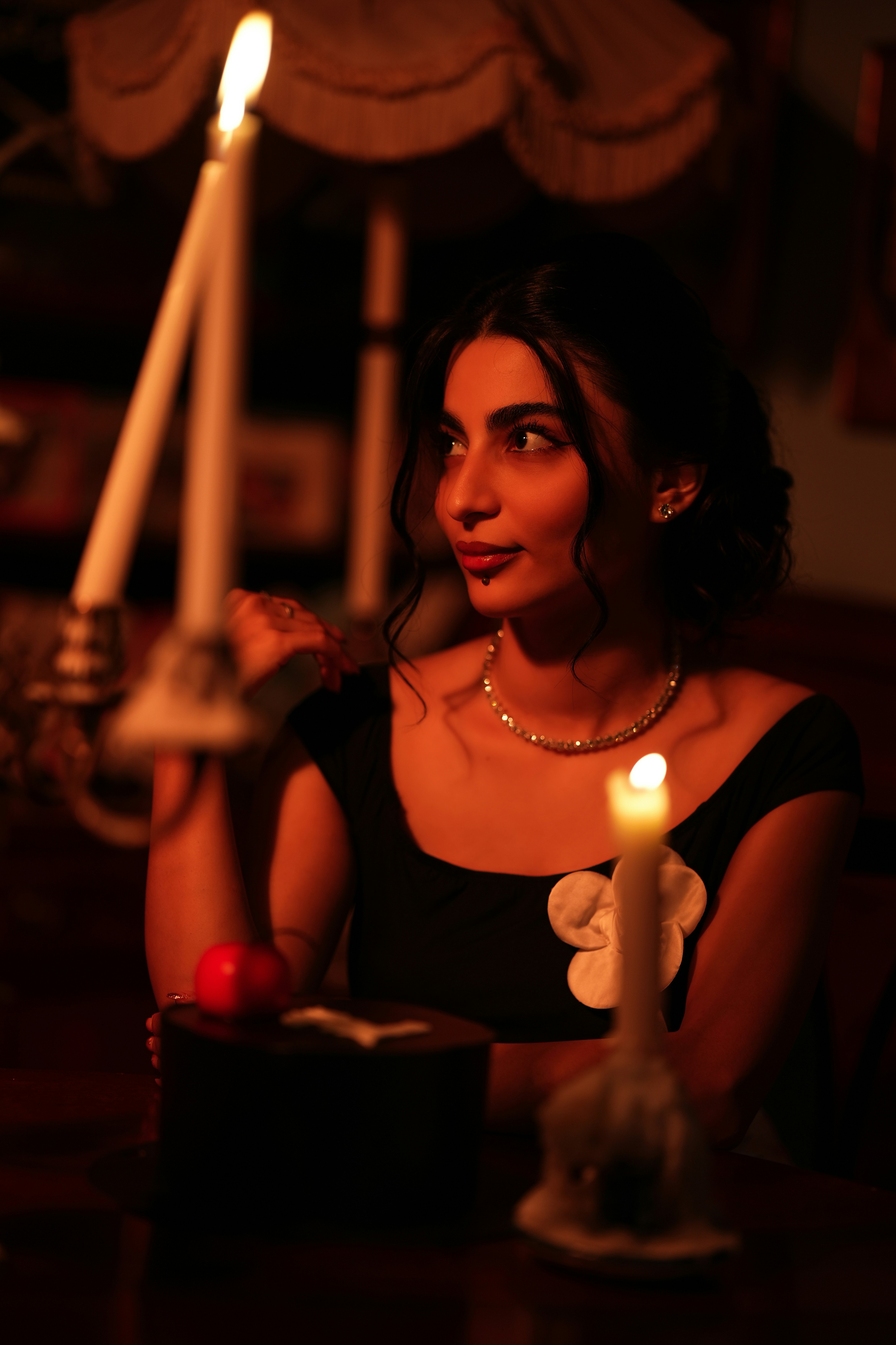 Seated at the table, a tall candle in the foreground