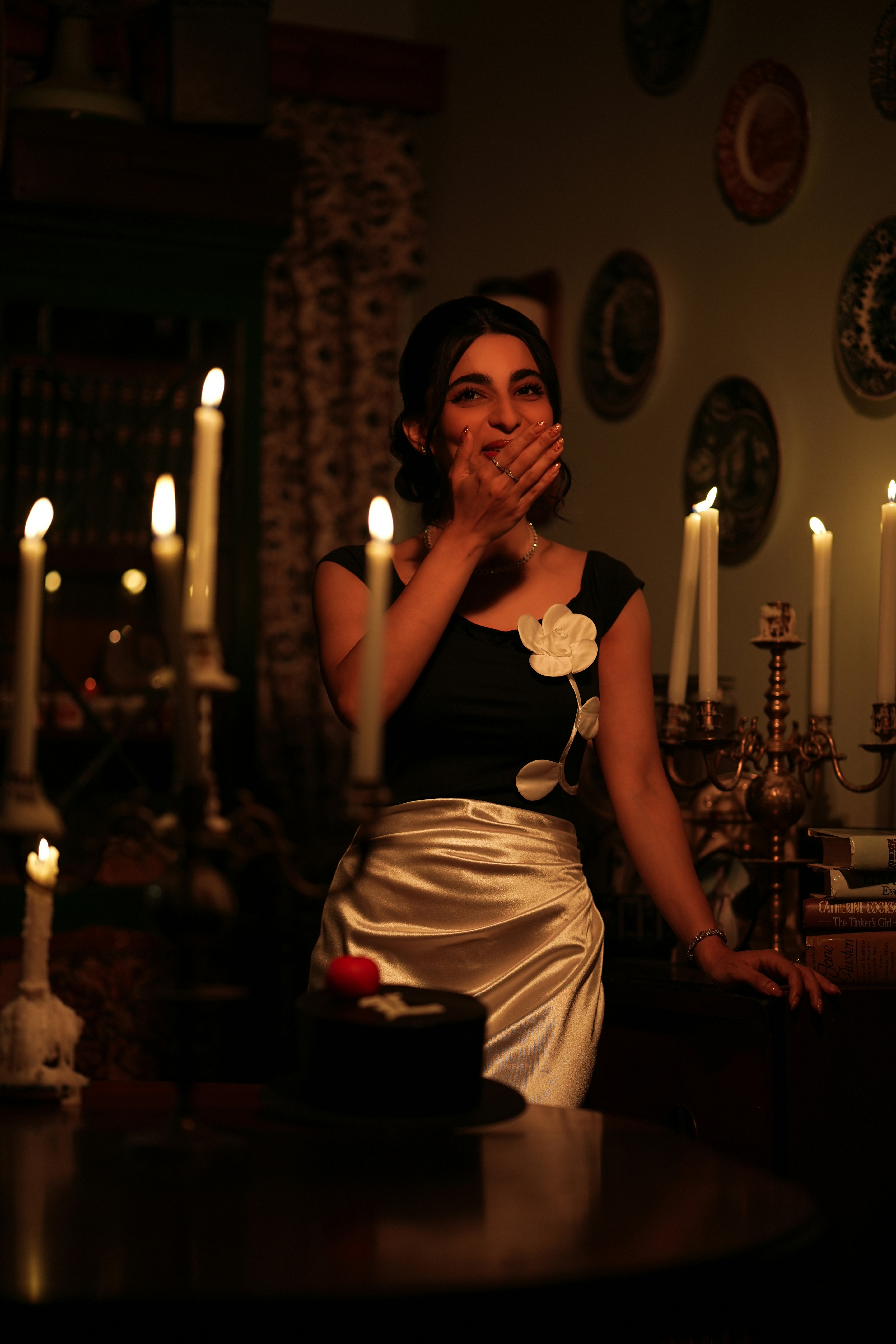 Laughing behind a hand, candelabra behind