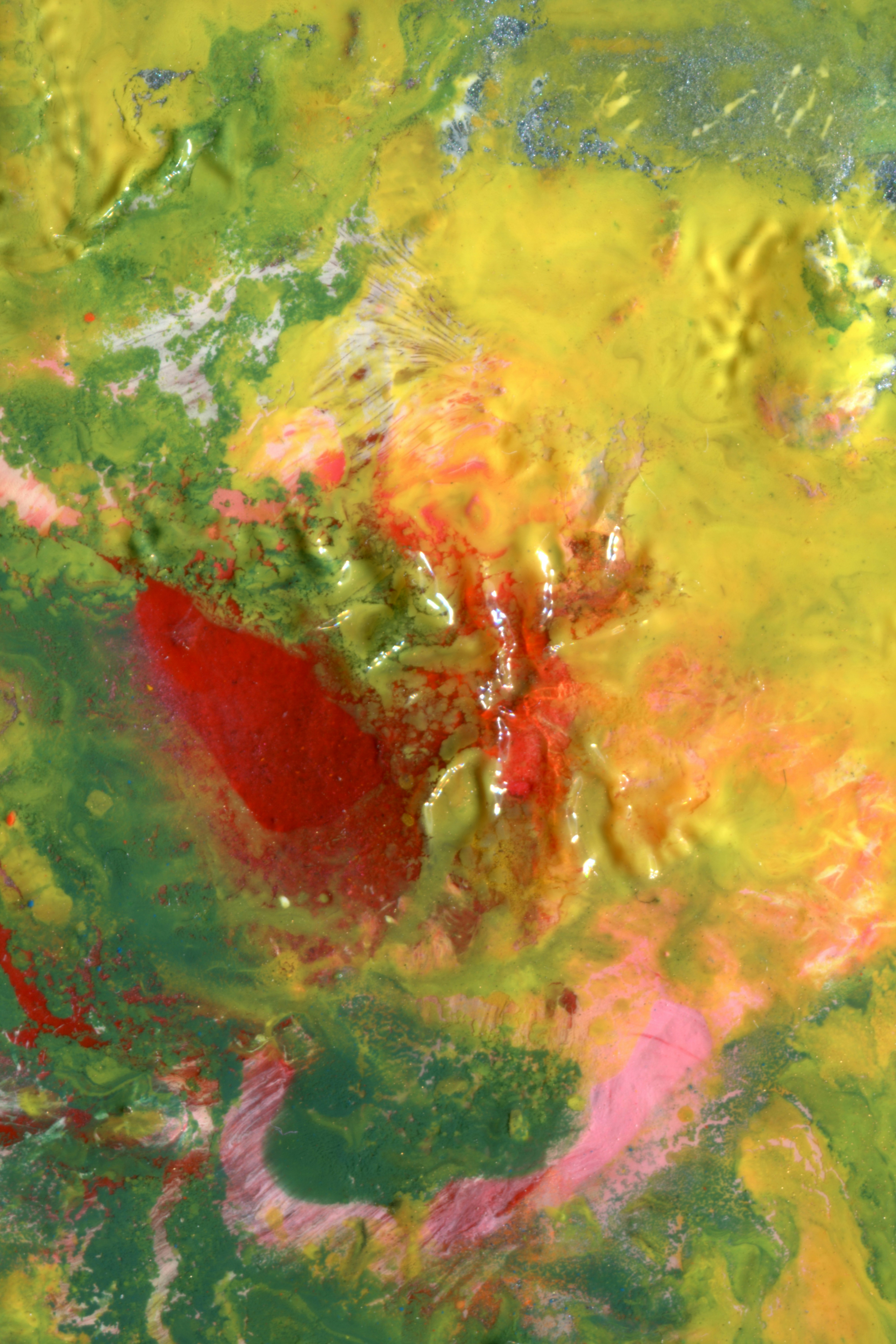 Abstract thick impasto paint texture in vibrant shades of yellow, green, and red