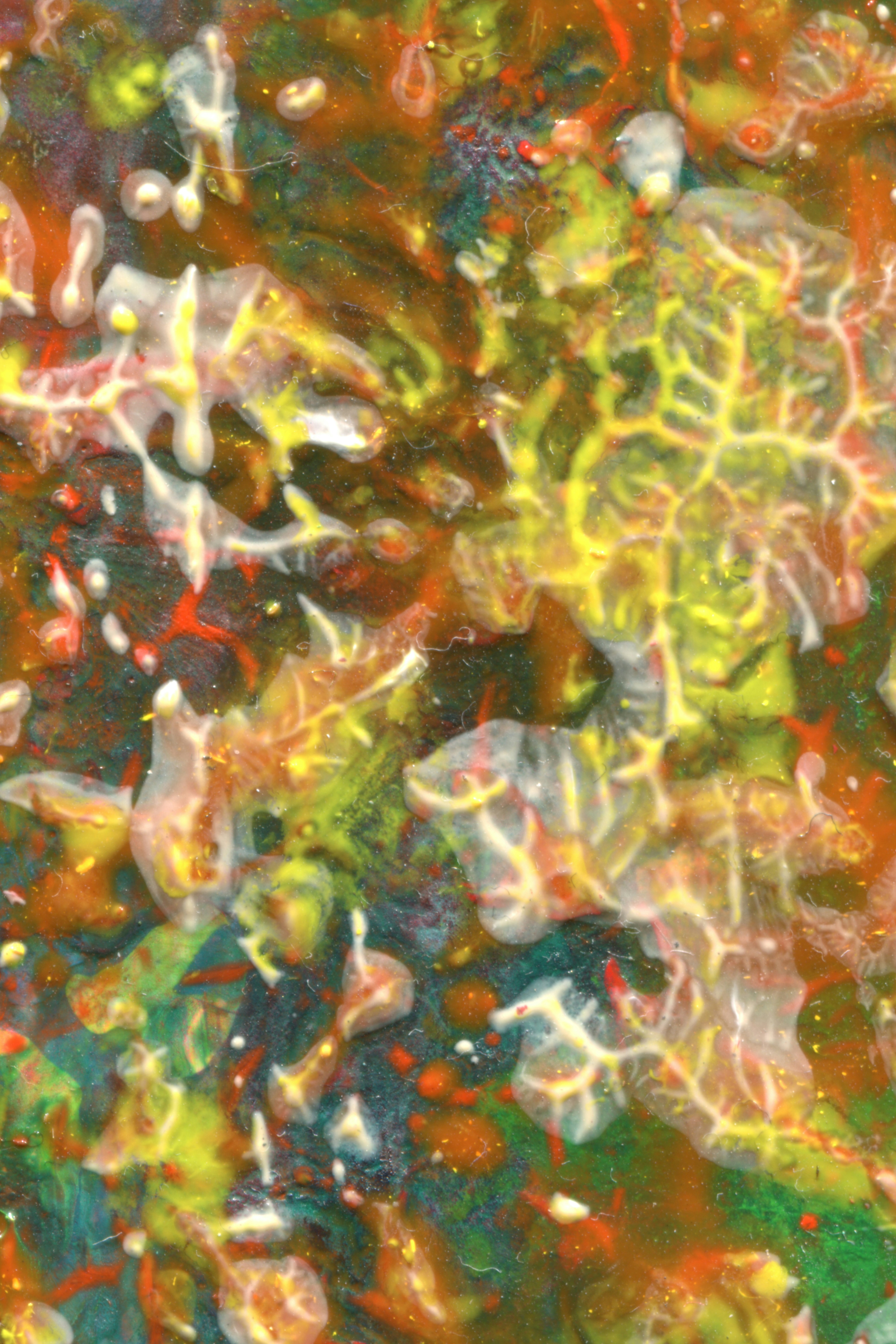 Abstract texture of swirling yellow, orange, and green paint with raised translucent ridges