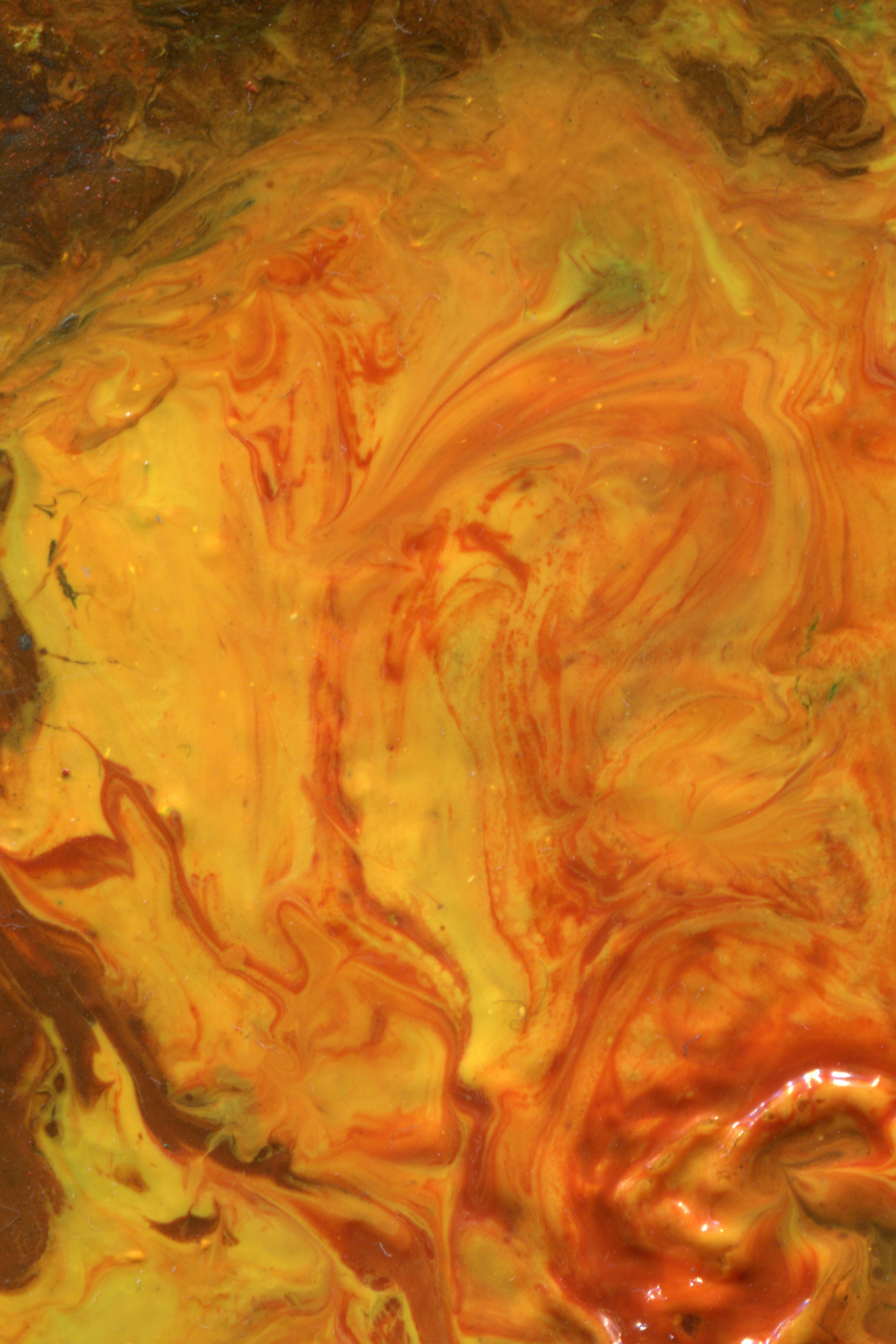 Swirling patterns of vibrant yellow and orange paint with glossy textures