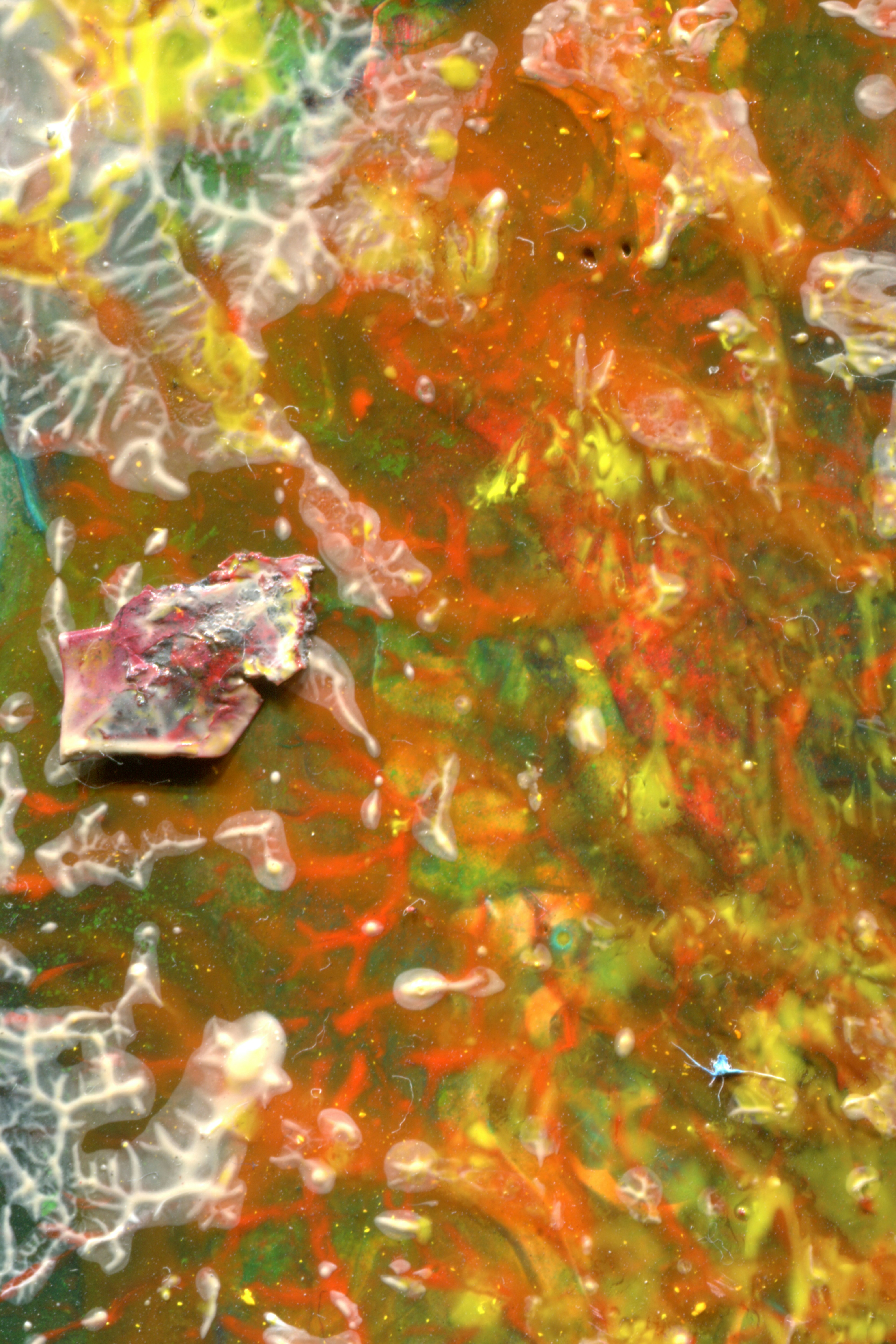 Abstract swirls of yellow, orange, and green paint with a textured fragment on the left