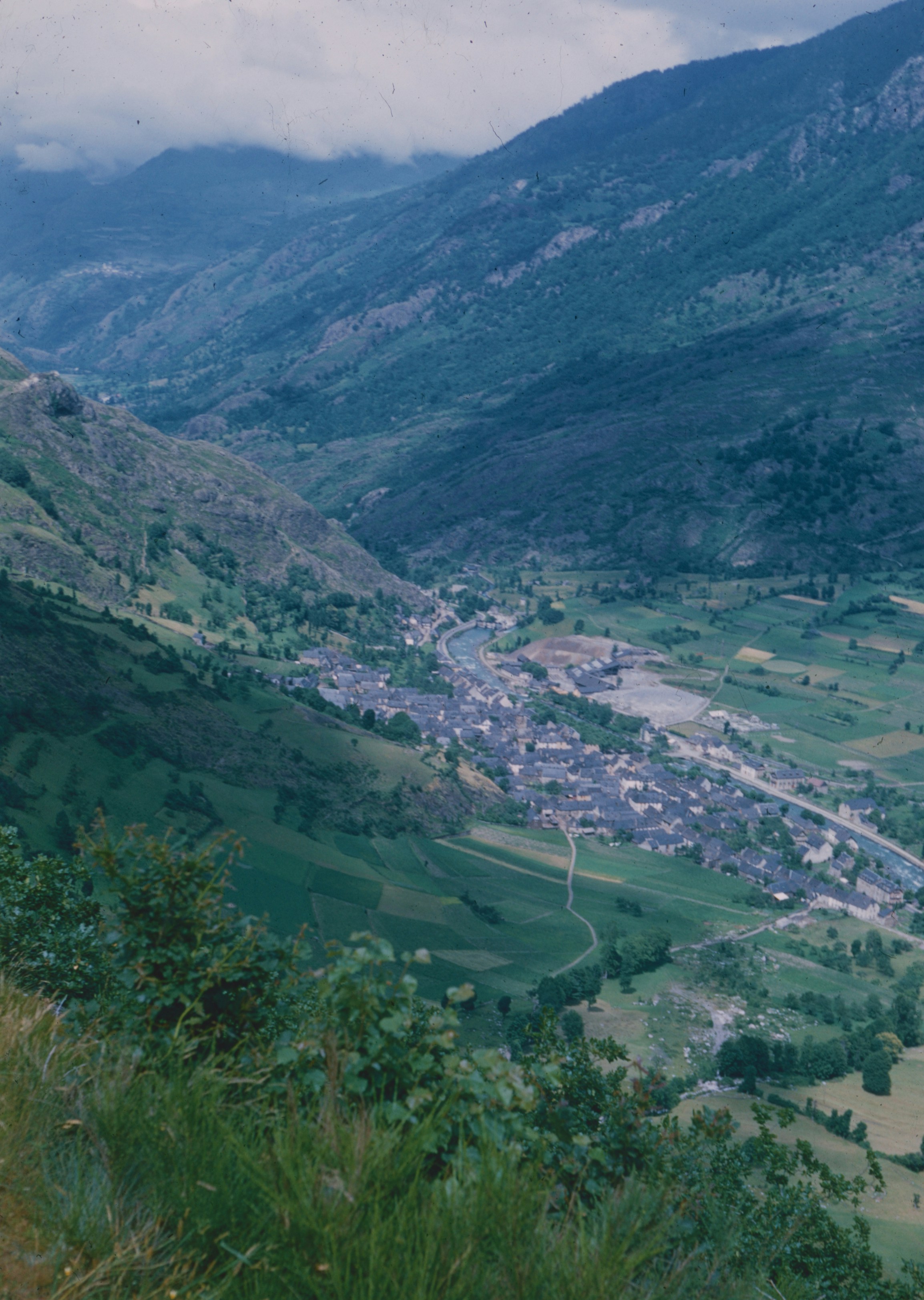 Fotomural A small village nestled in a lush green valley between steep mountain slopes