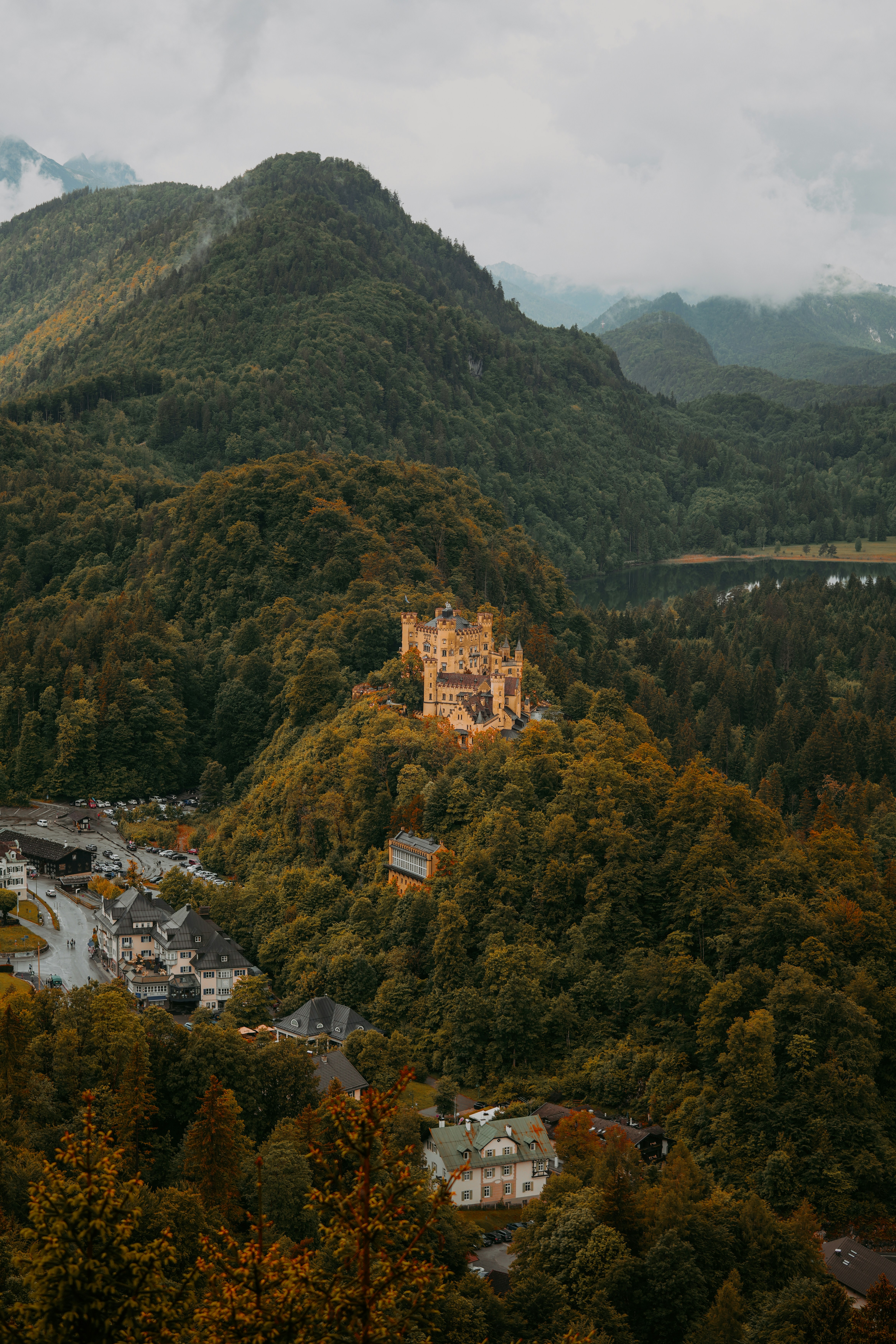 Hohenschwangau Castle perched on a forested hill above a village in Bavaria