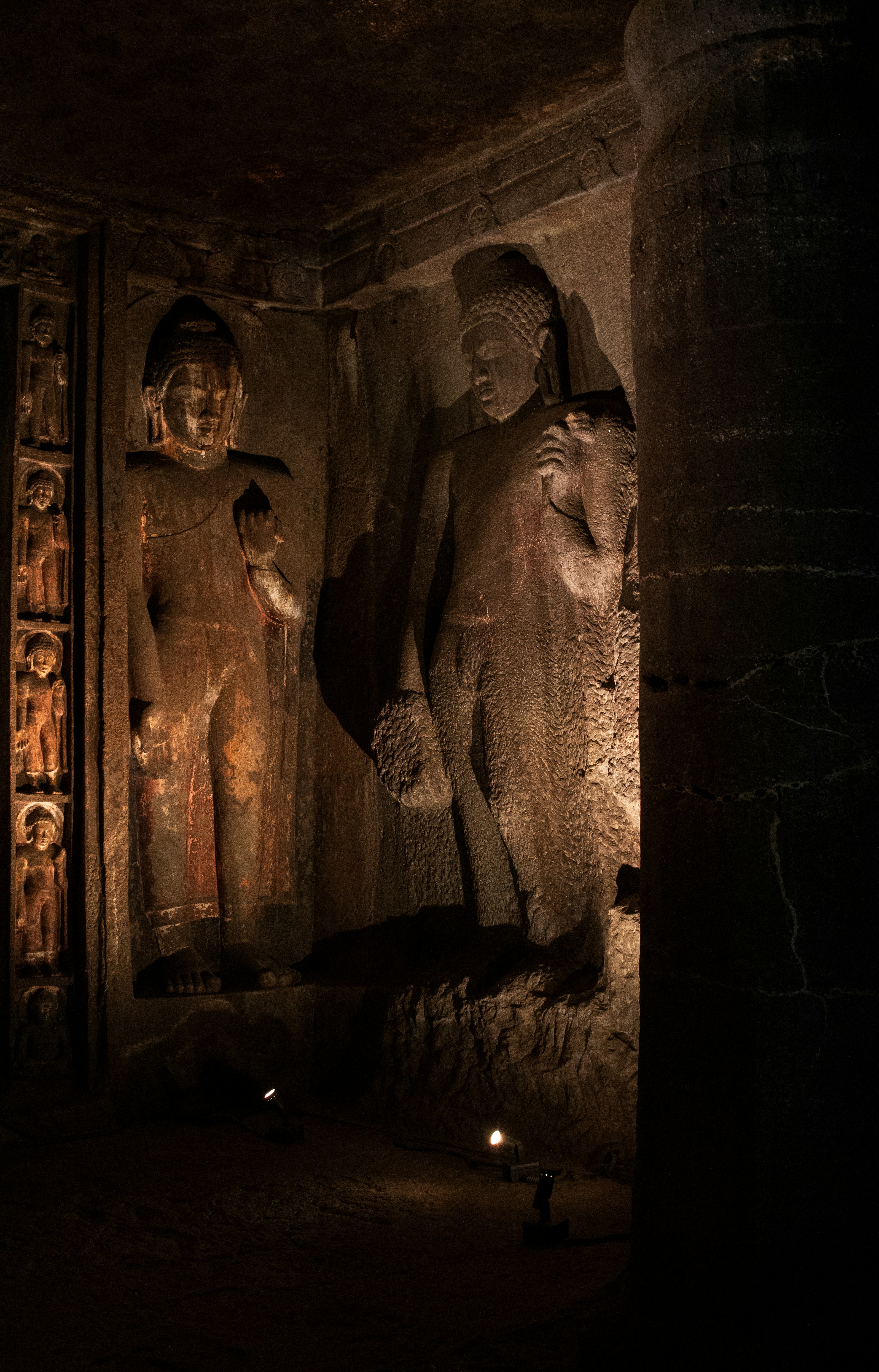 Standing Buddha statues carved into the rock walls of the Ajanta Caves in Maharashtra, India