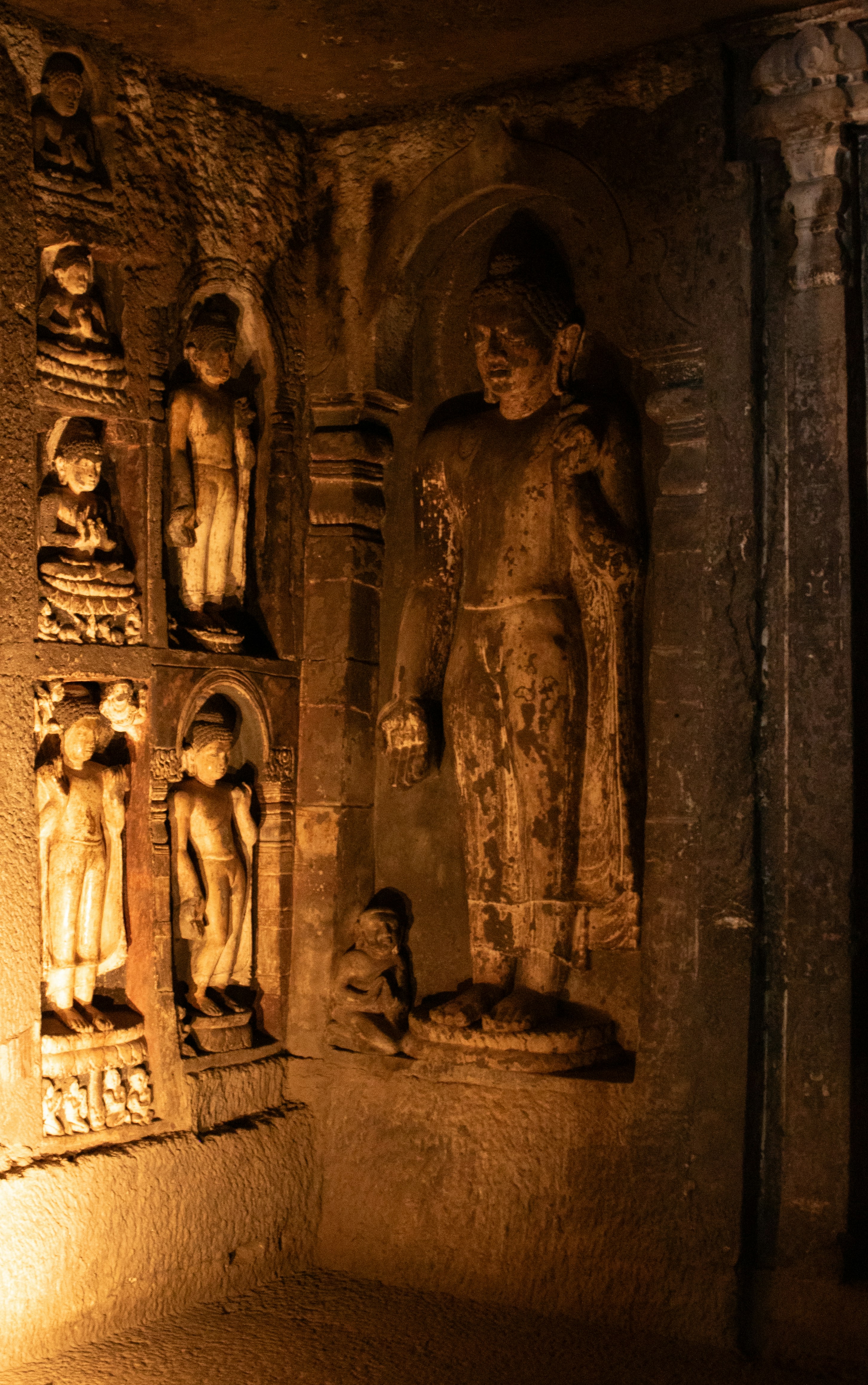 Stone Buddha sculptures carved into the rock walls of the Ajanta Caves in India