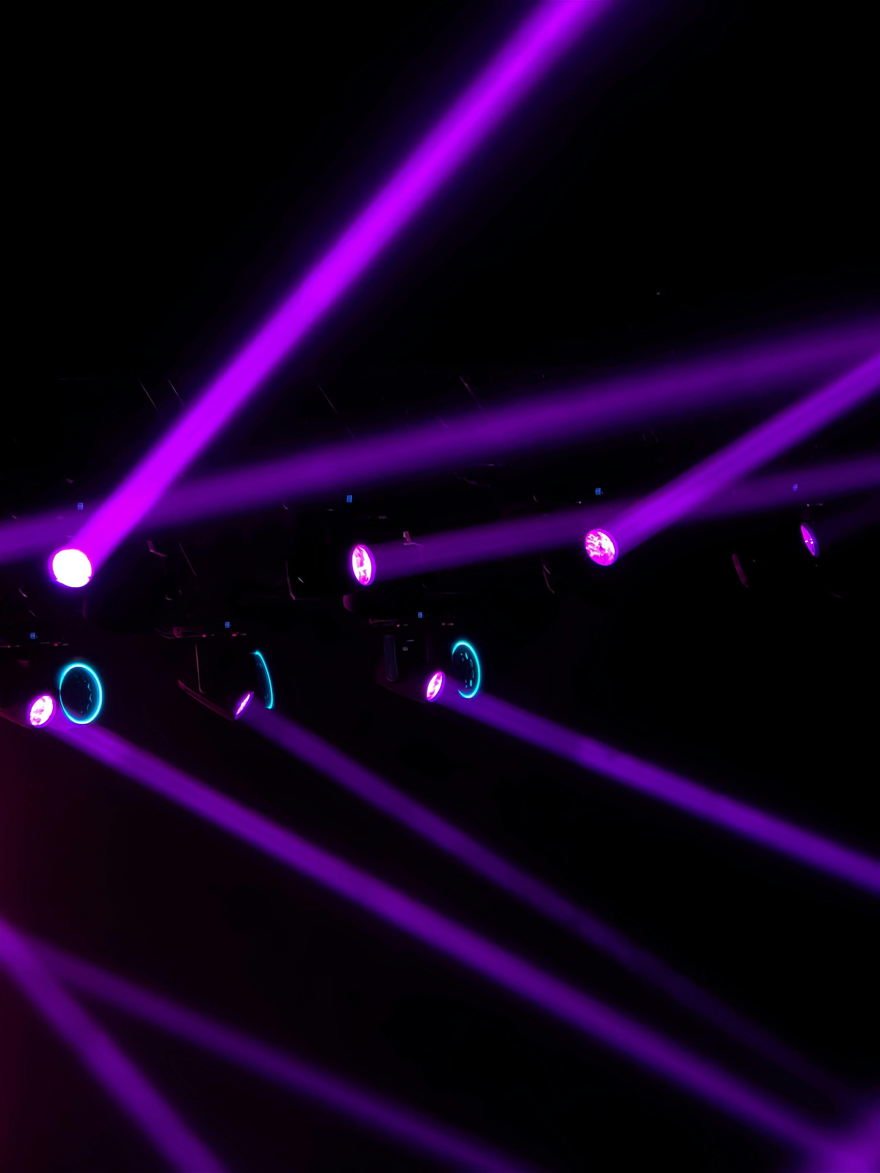 Bright purple stage lights casting beams through a dark atmosphere