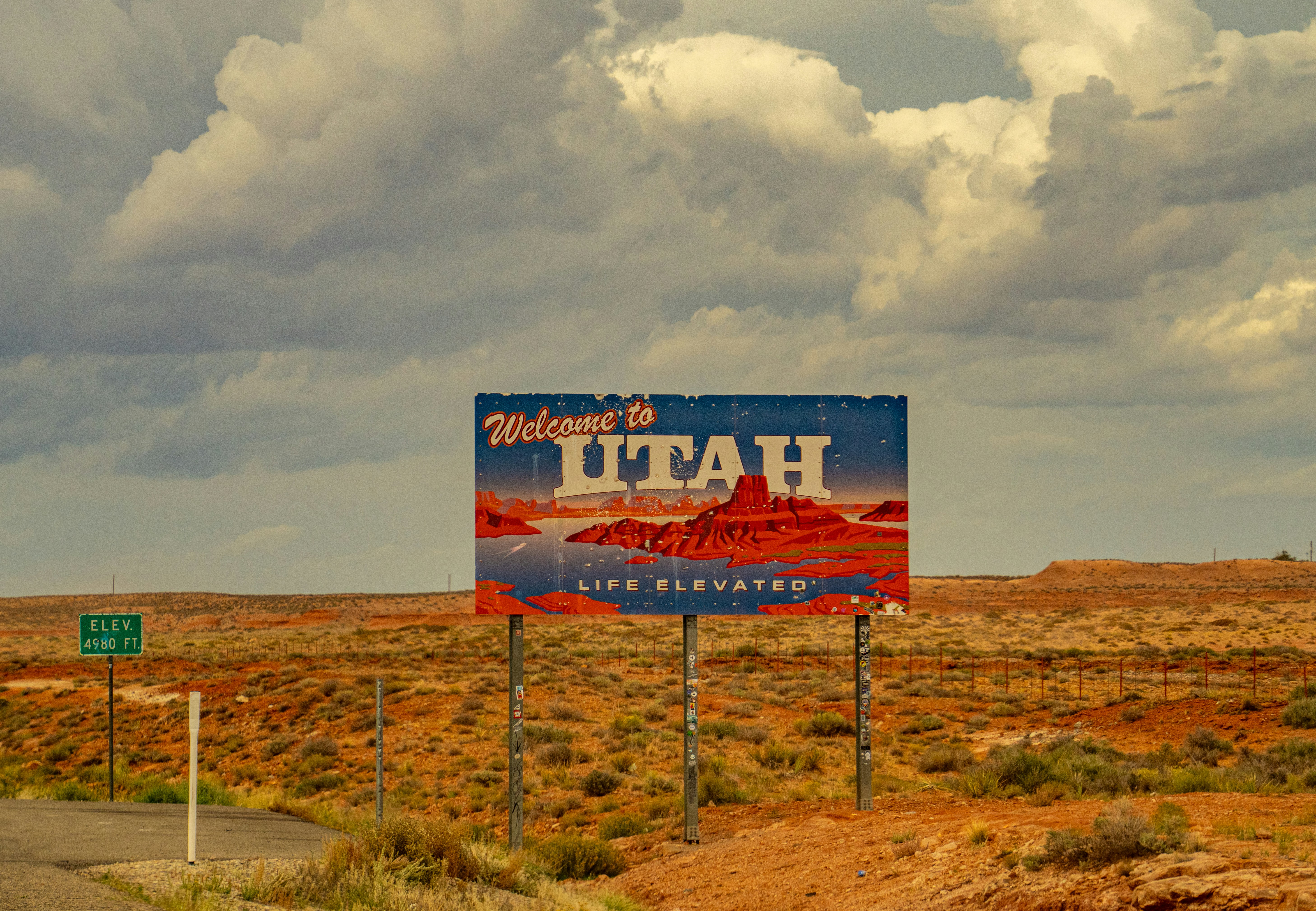 Un cartello di benvenuto nello Utah in un paesaggio desertico sotto un cielo nuvoloso