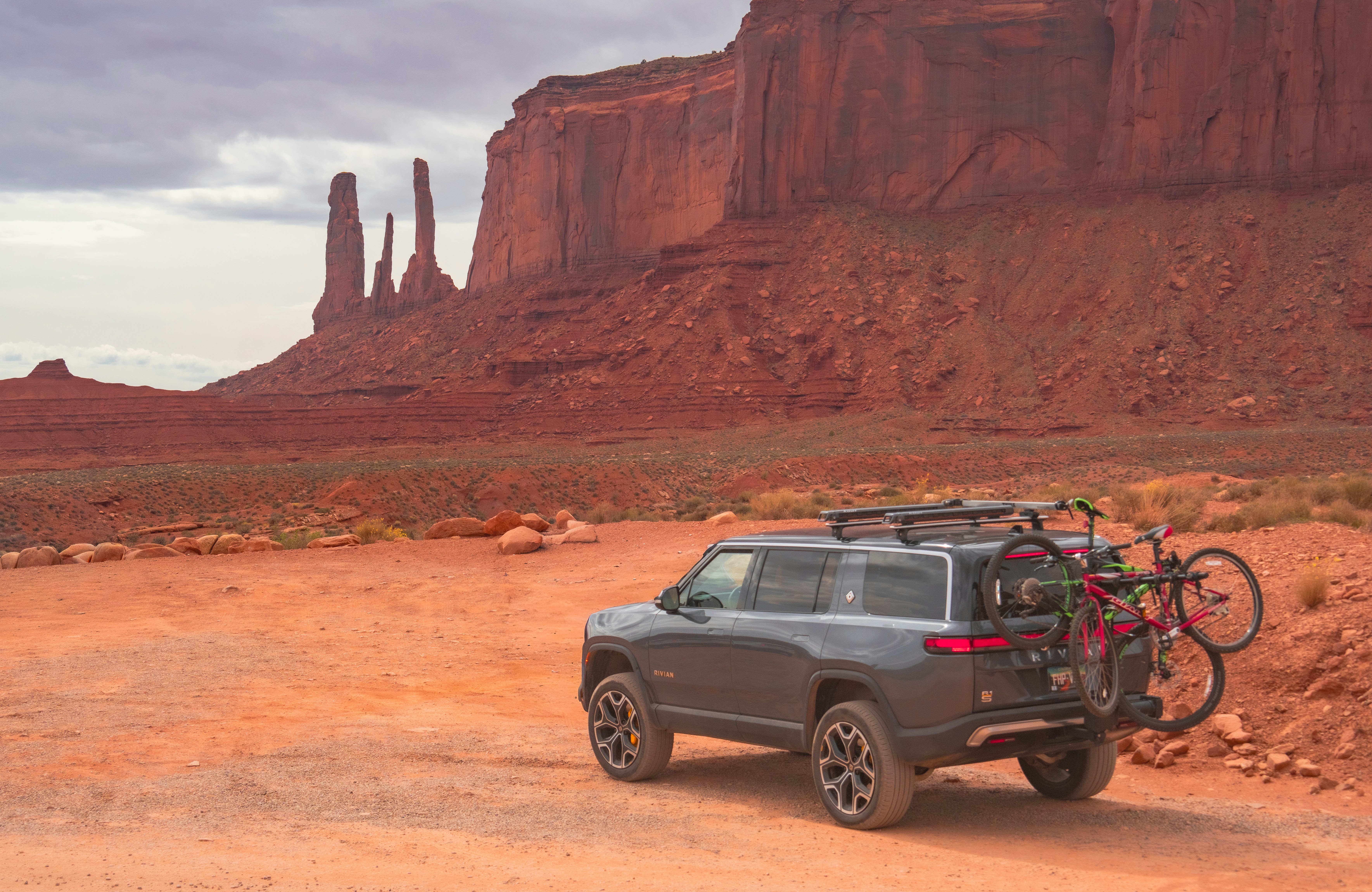 Un SUV grigio con biciclette su un portapacchi posteriore parcheggiato a Monument Valley