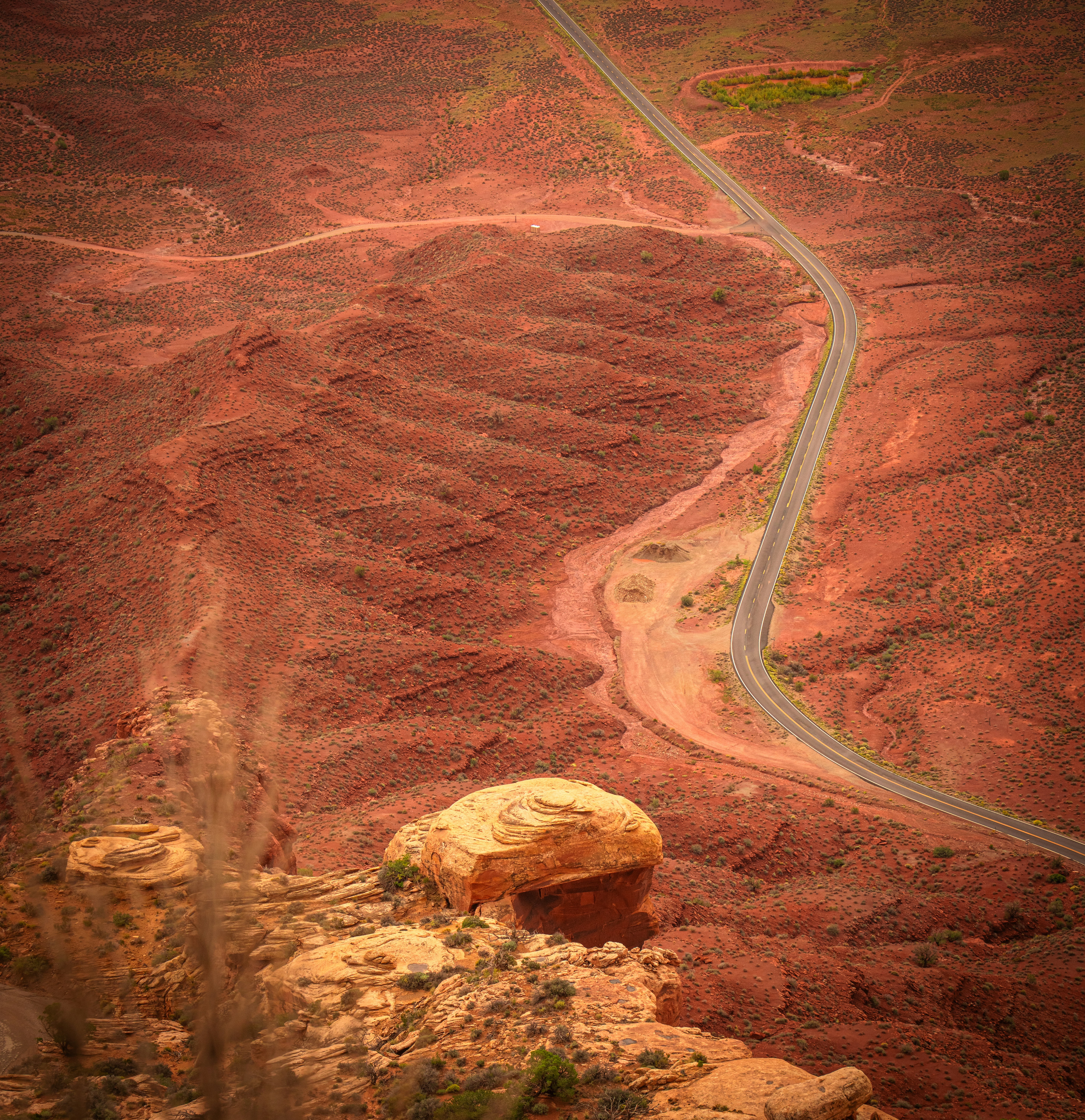 Una vista aerea di una strada tortuosa attraverso un vasto paesaggio desertico rosso