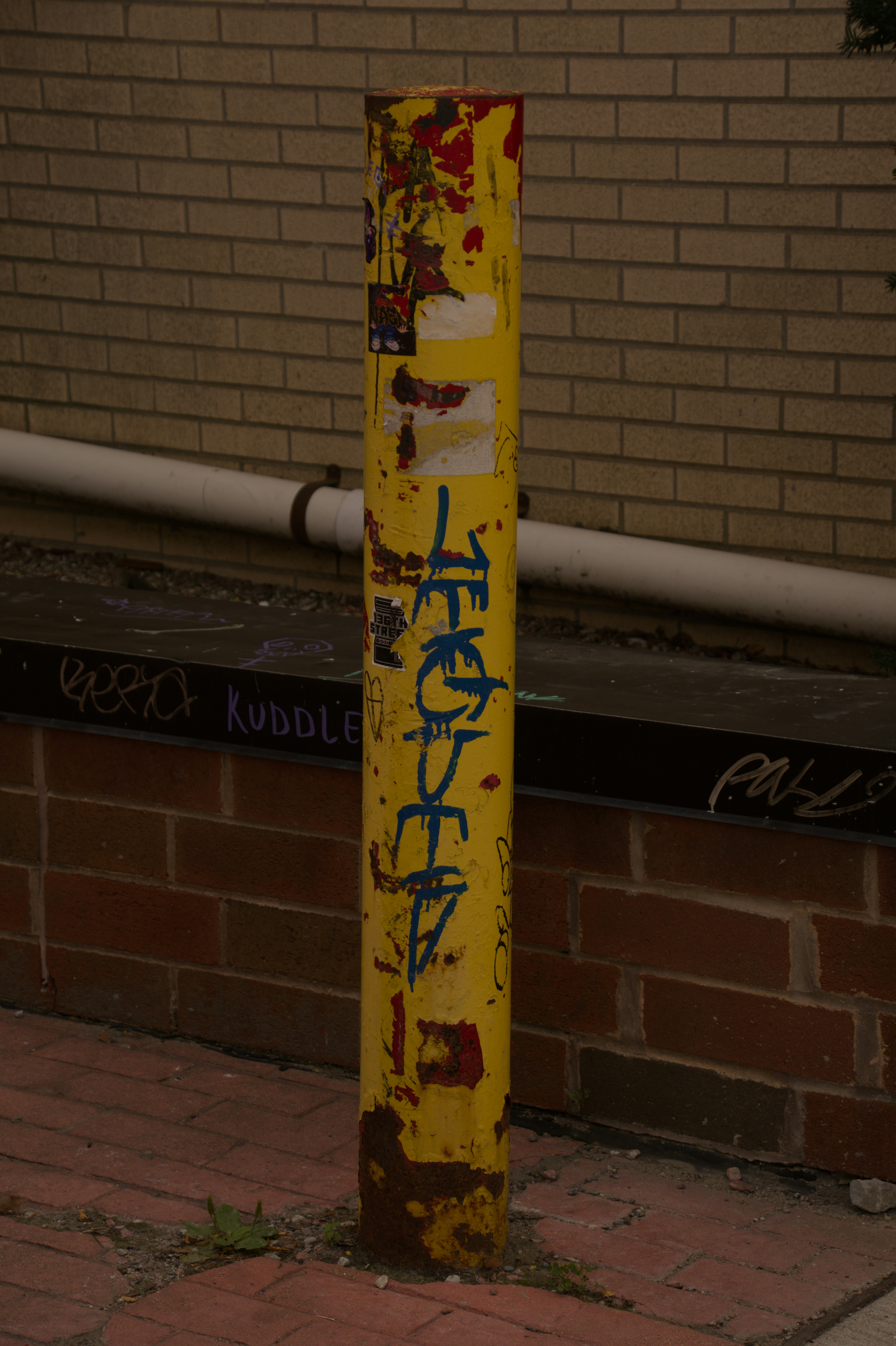Weathered yellow bollard with graffiti - Free Photo on Unsplash