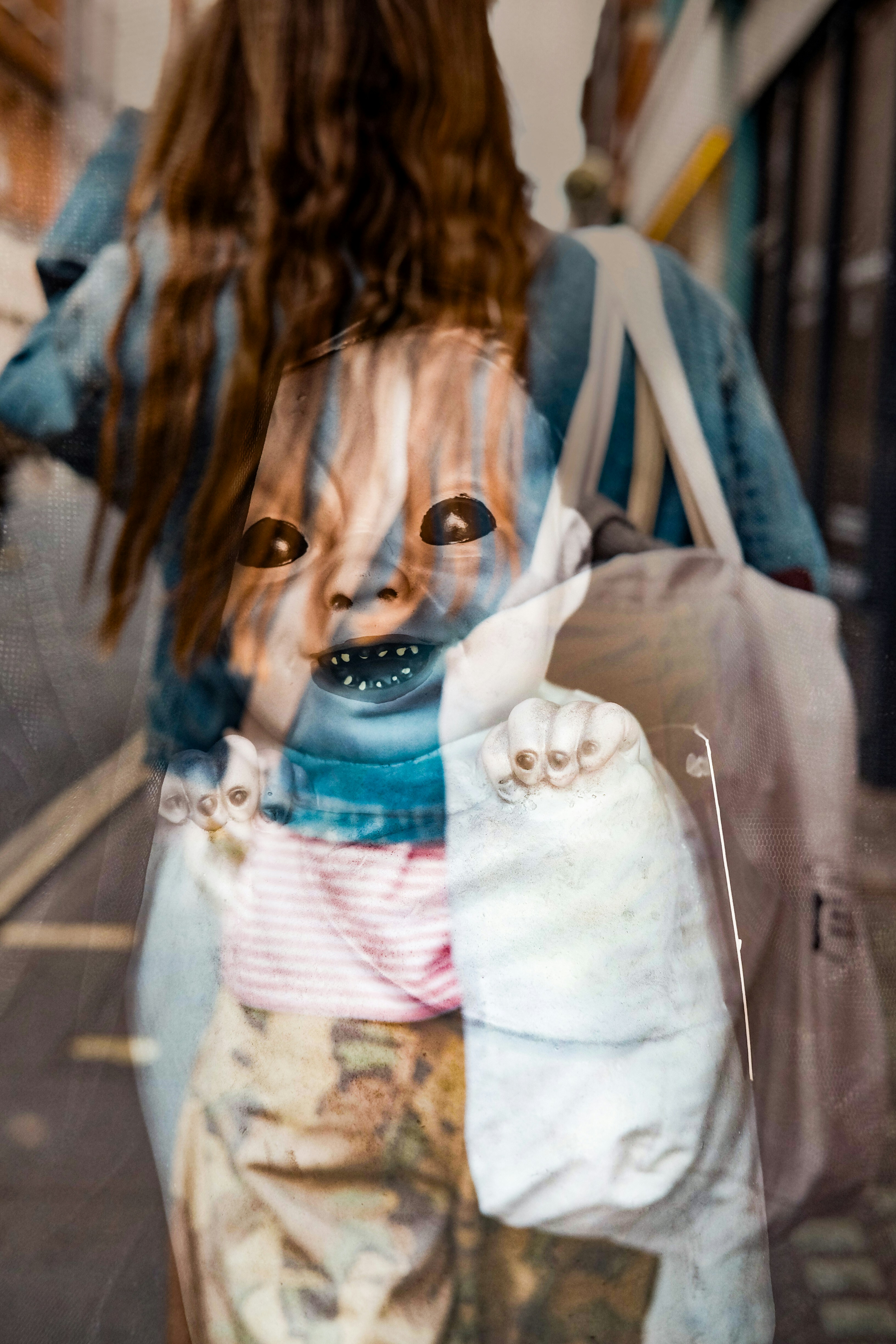 A double exposure of a person with long hair and a doll face