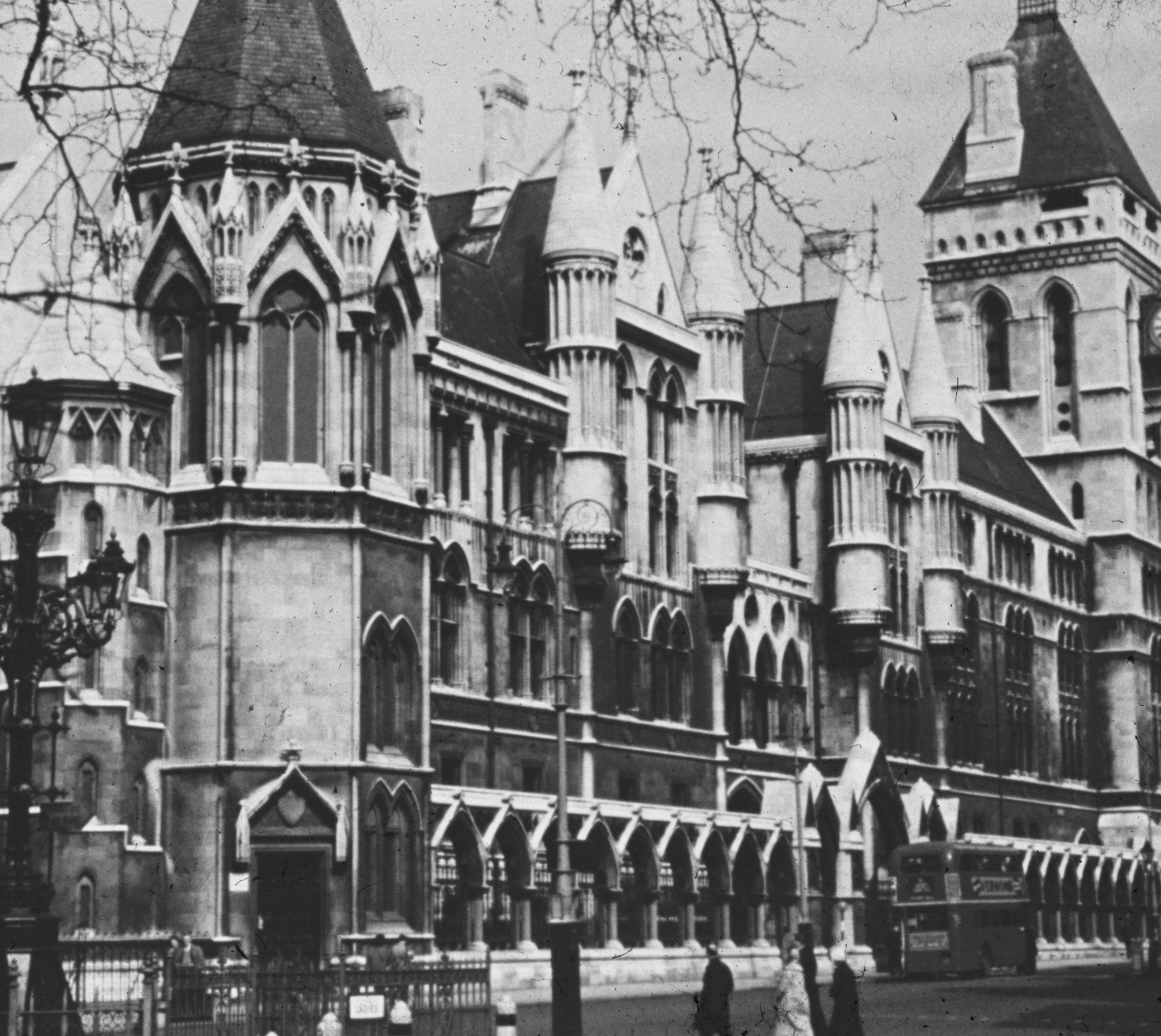 The Royal Courts of Justice in London with a double-decker bus on the street