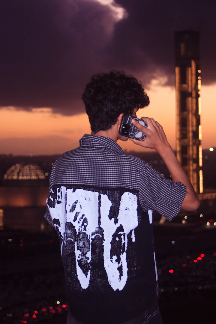 Person talking on a phone against a warm city skyline