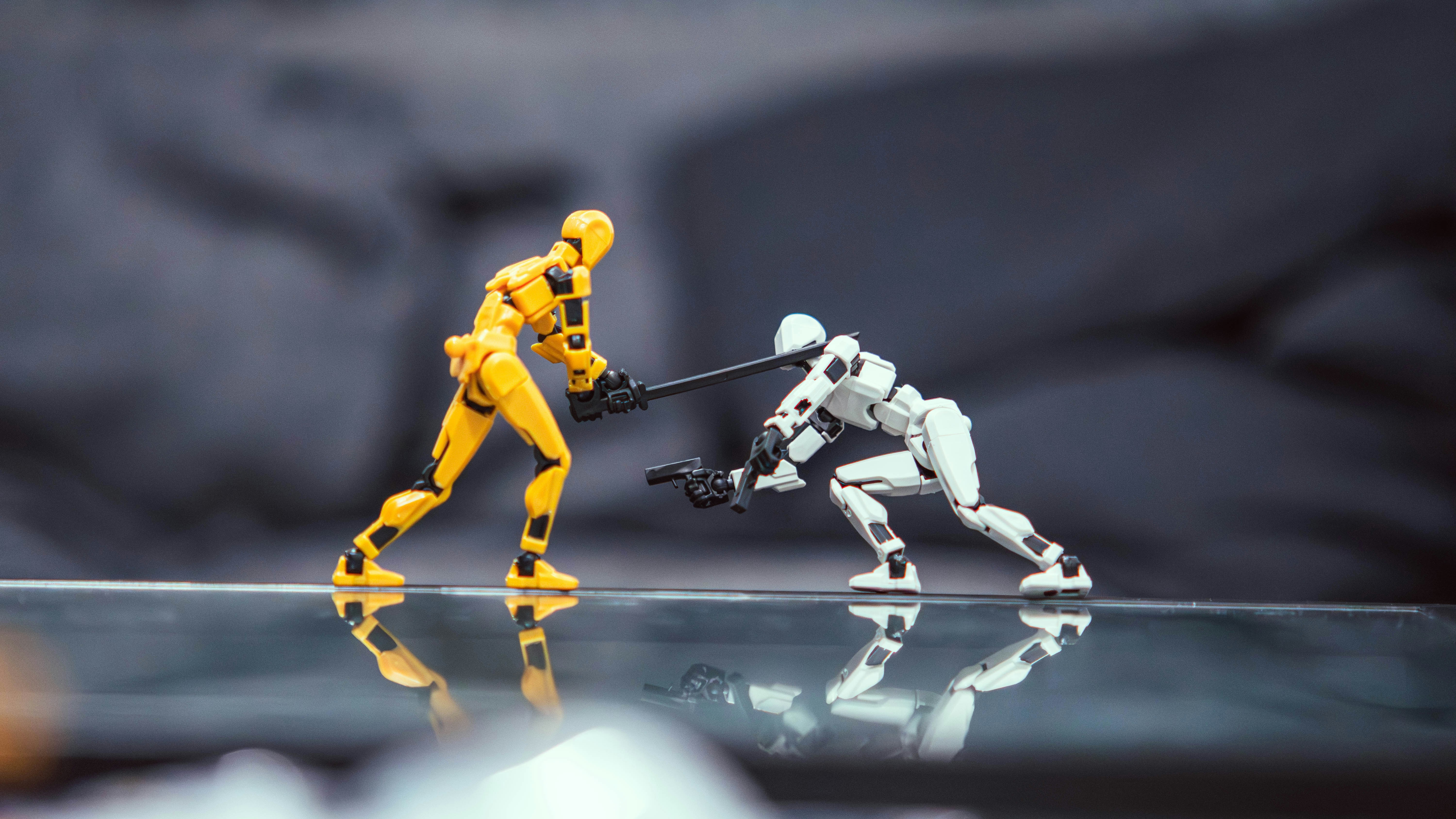 A yellow and a white articulated action figure dueling with a sword and a pistol