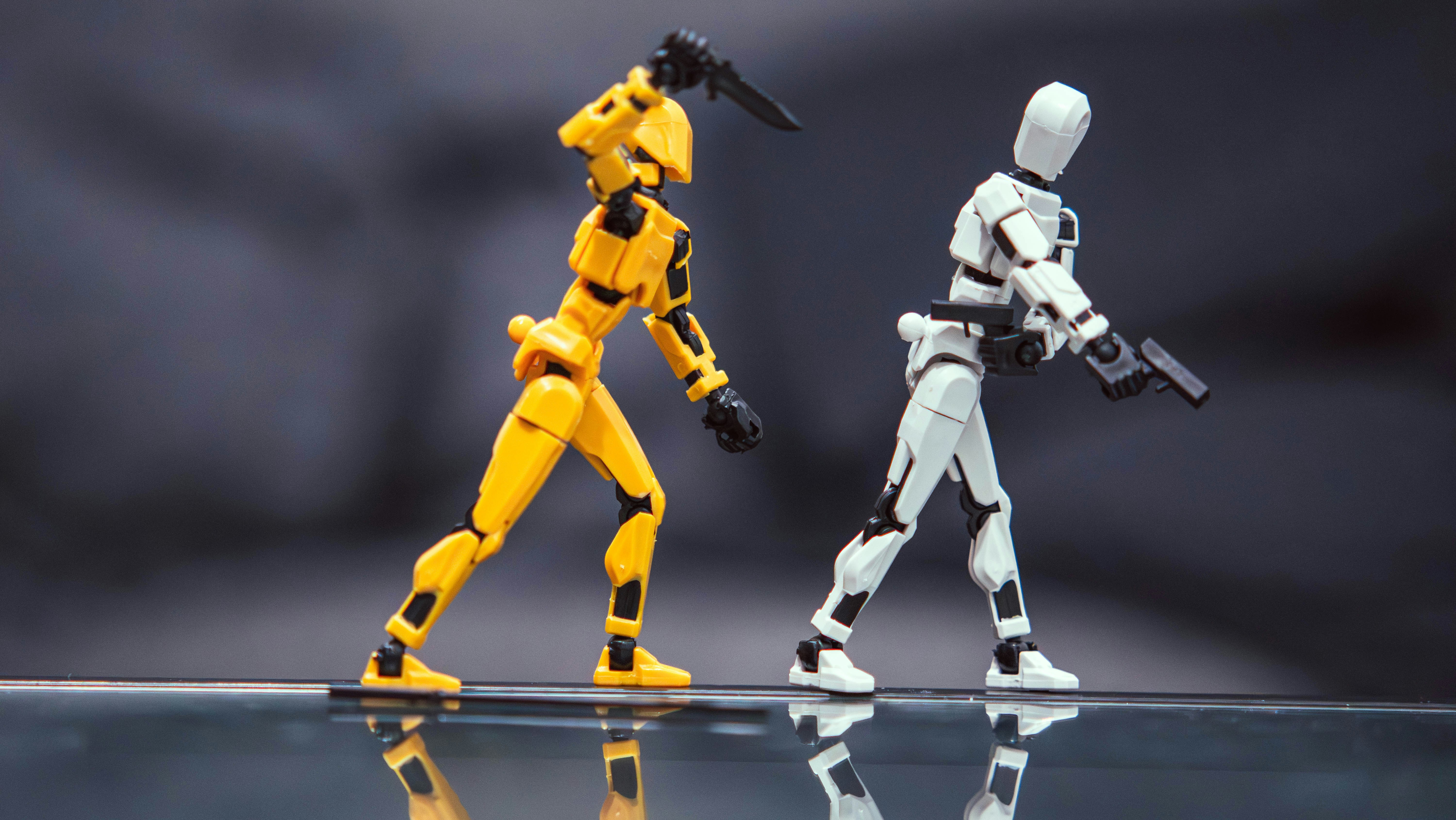 A yellow action figure with a knife and a white action figure with a pistol