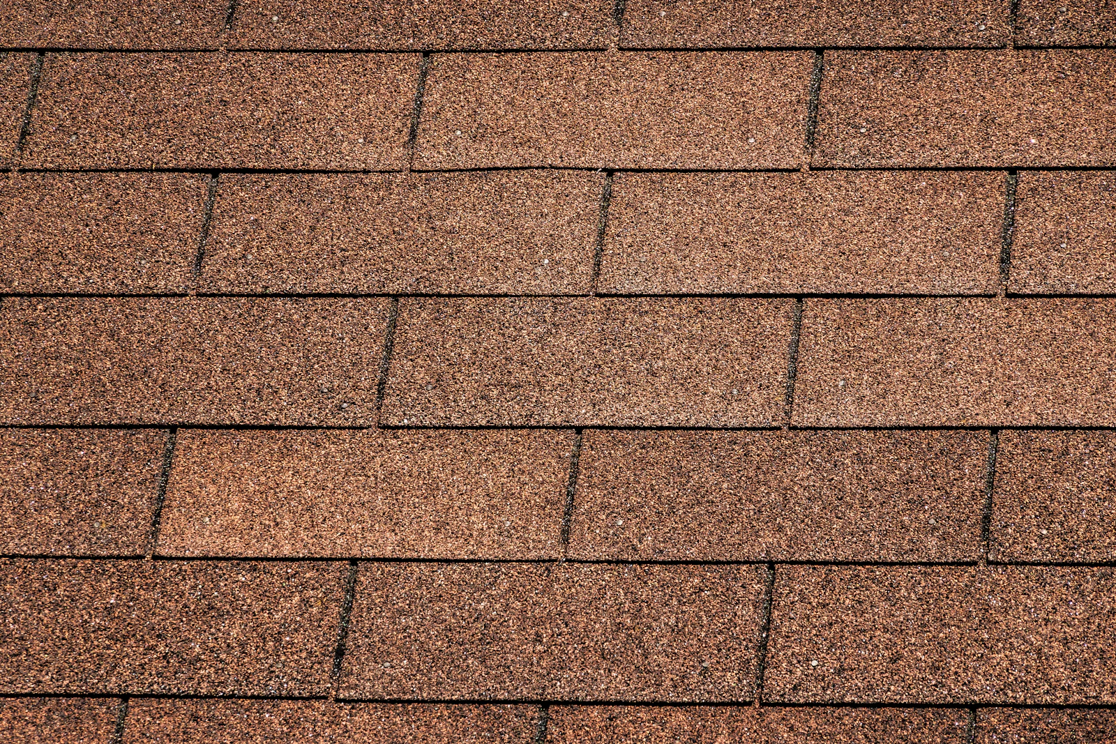 Close-up of overlapping asphalt roof shingles on a residential roof