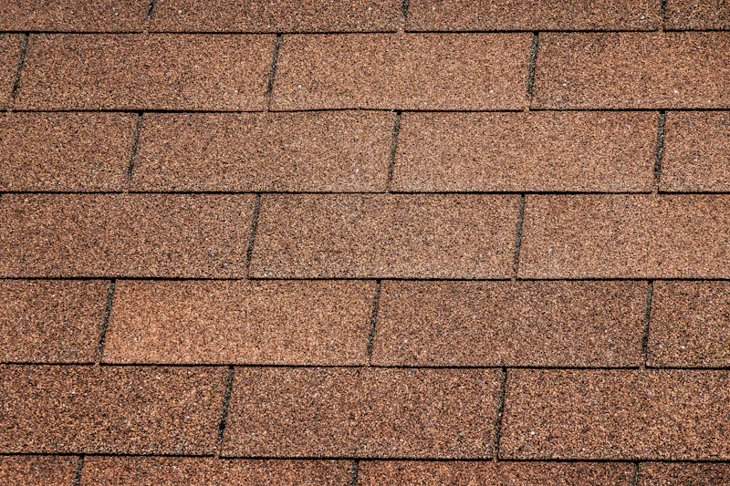 Close-up of overlapping asphalt roof shingles on a residential roof