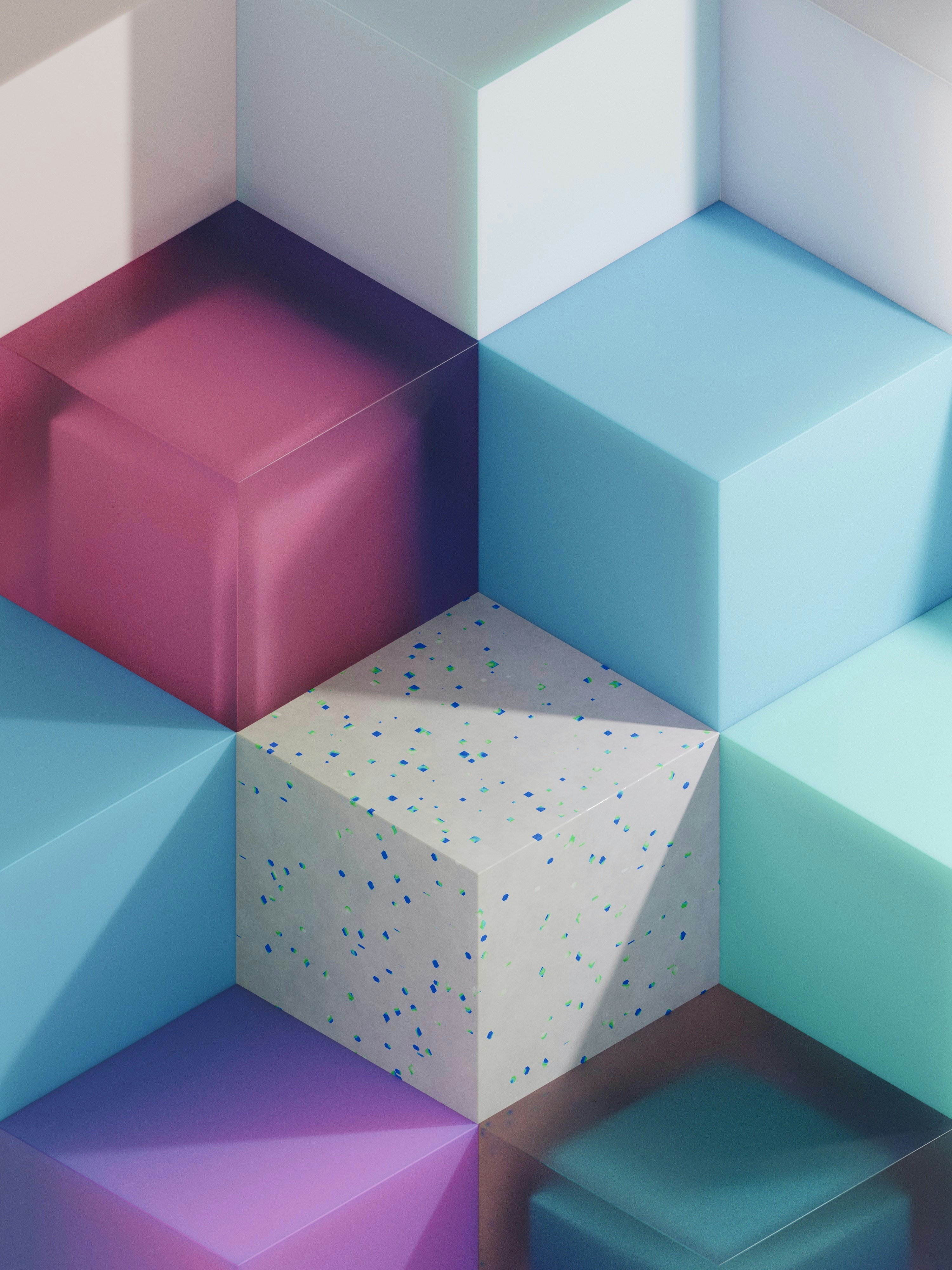 A 3D render of colorful translucent and speckled cubes arranged in a geometric pattern