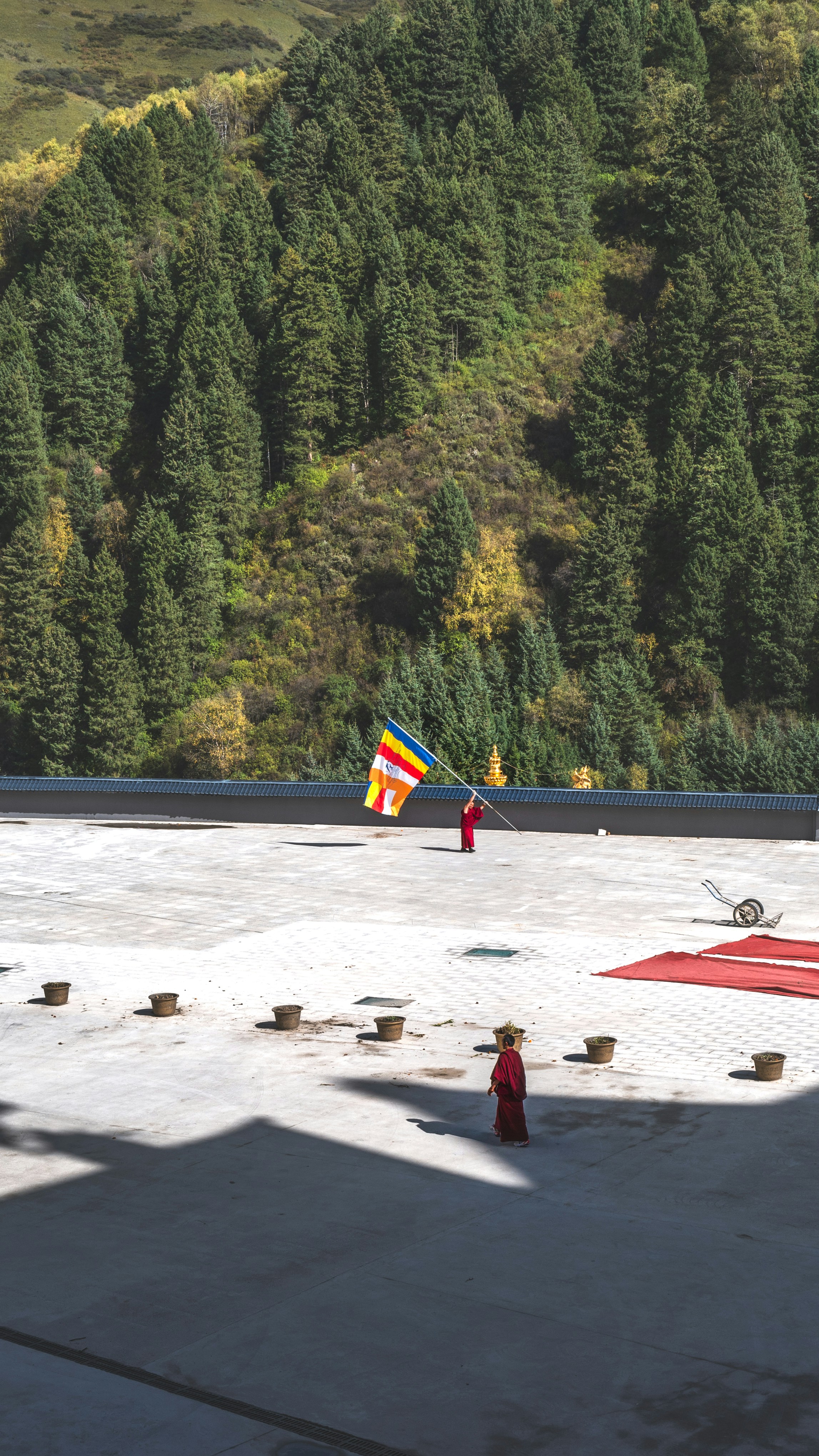 Monk holding flag on stone courtyard - Free Photo on Unsplash