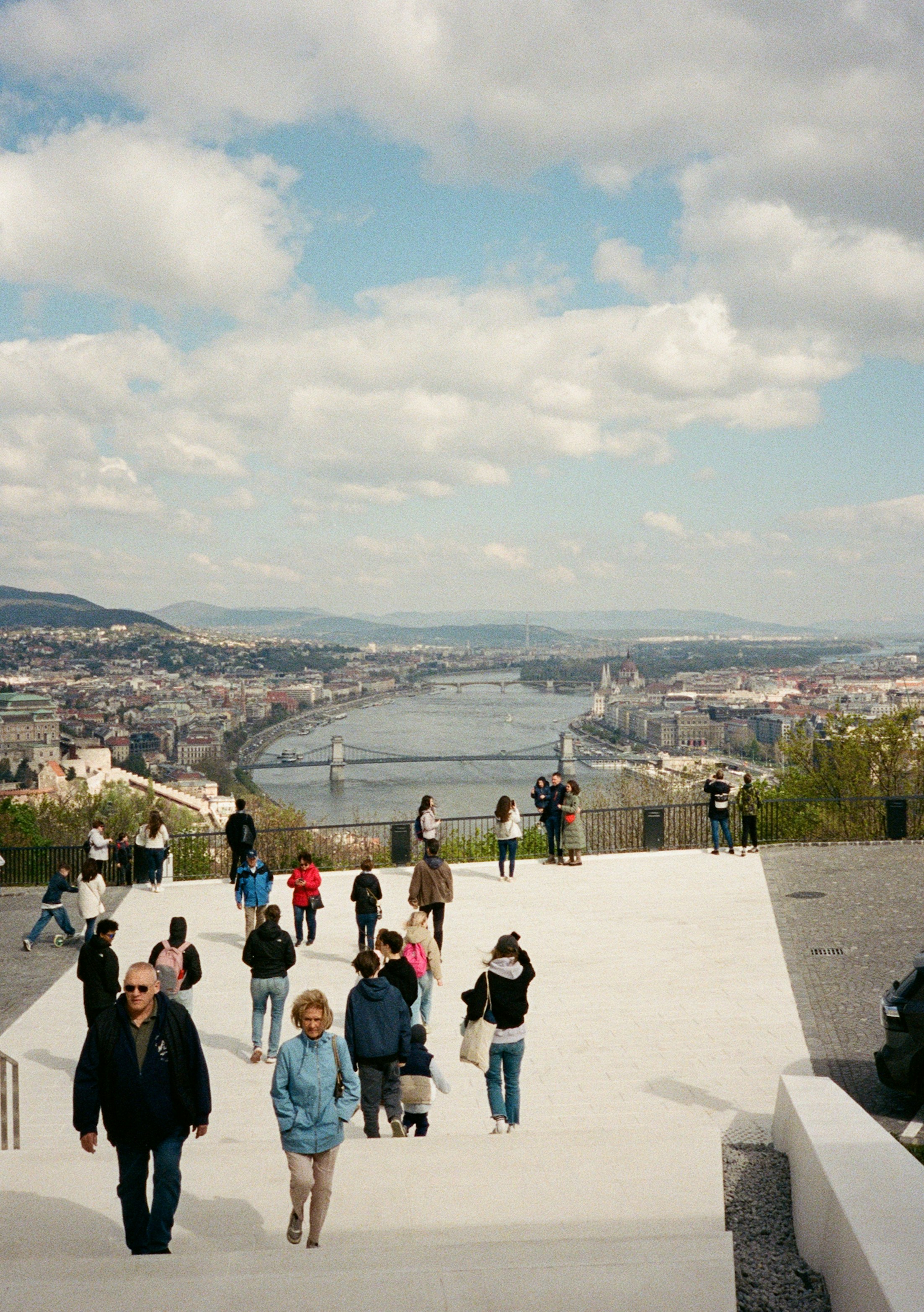 Menschen, die auf einer Terrasse mit Blick auf die Donau und die Kettenbrücke in Budapest spazieren gehen