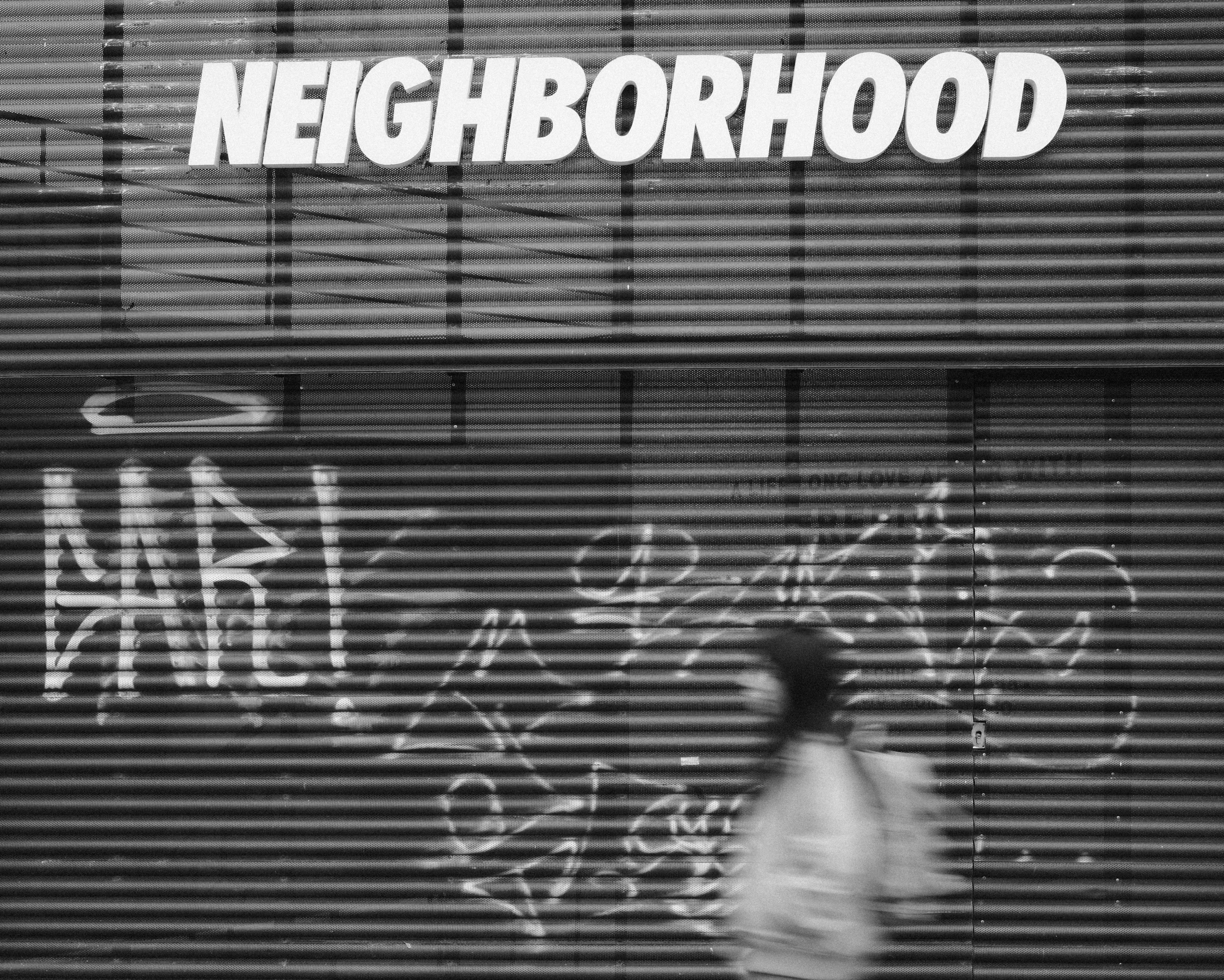 Blurred person passing graffiti shutter - Free Photo on Unsplash