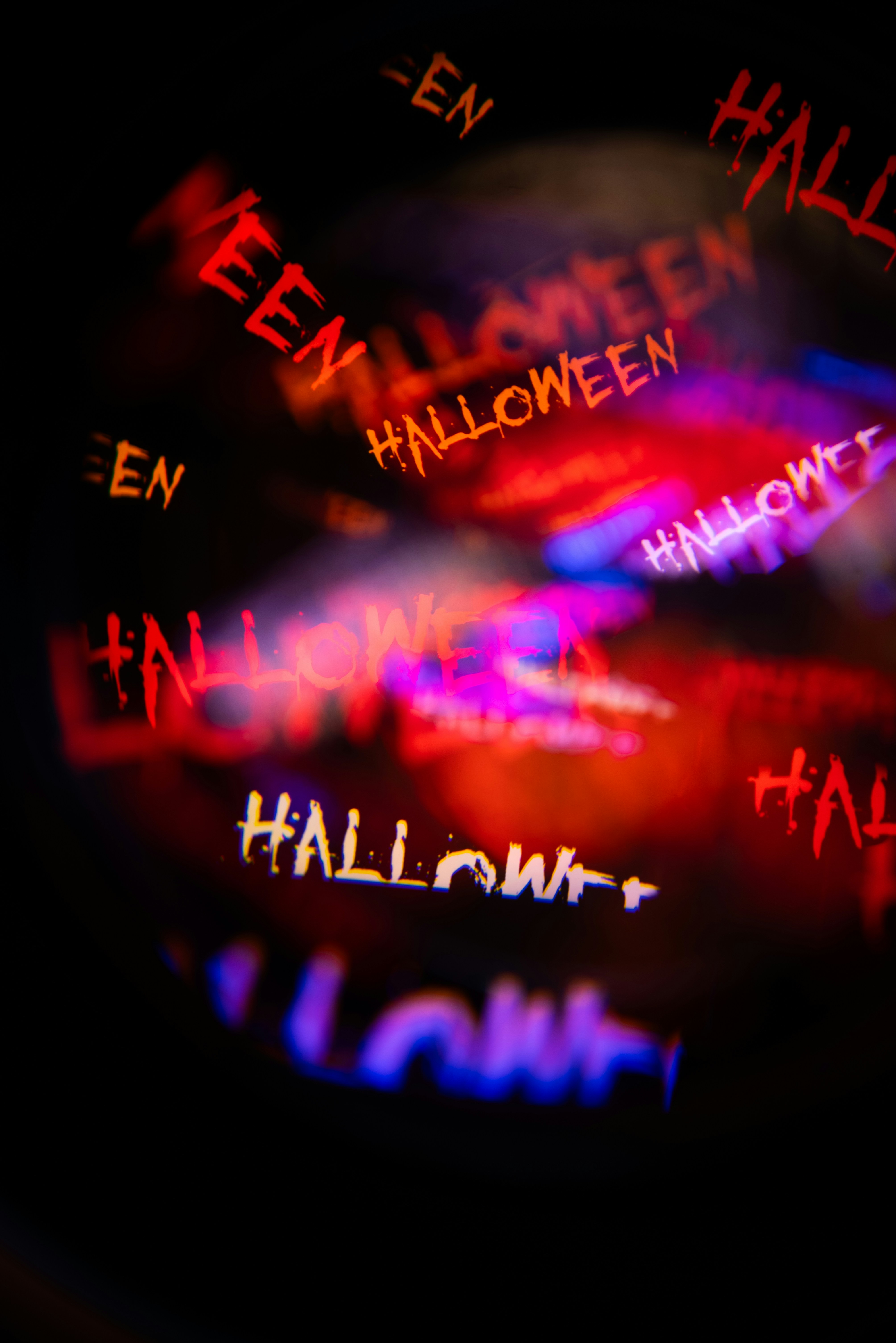 Plusieurs reflets flous de texte d’Halloween rouges et blancs sur un fond sombre
