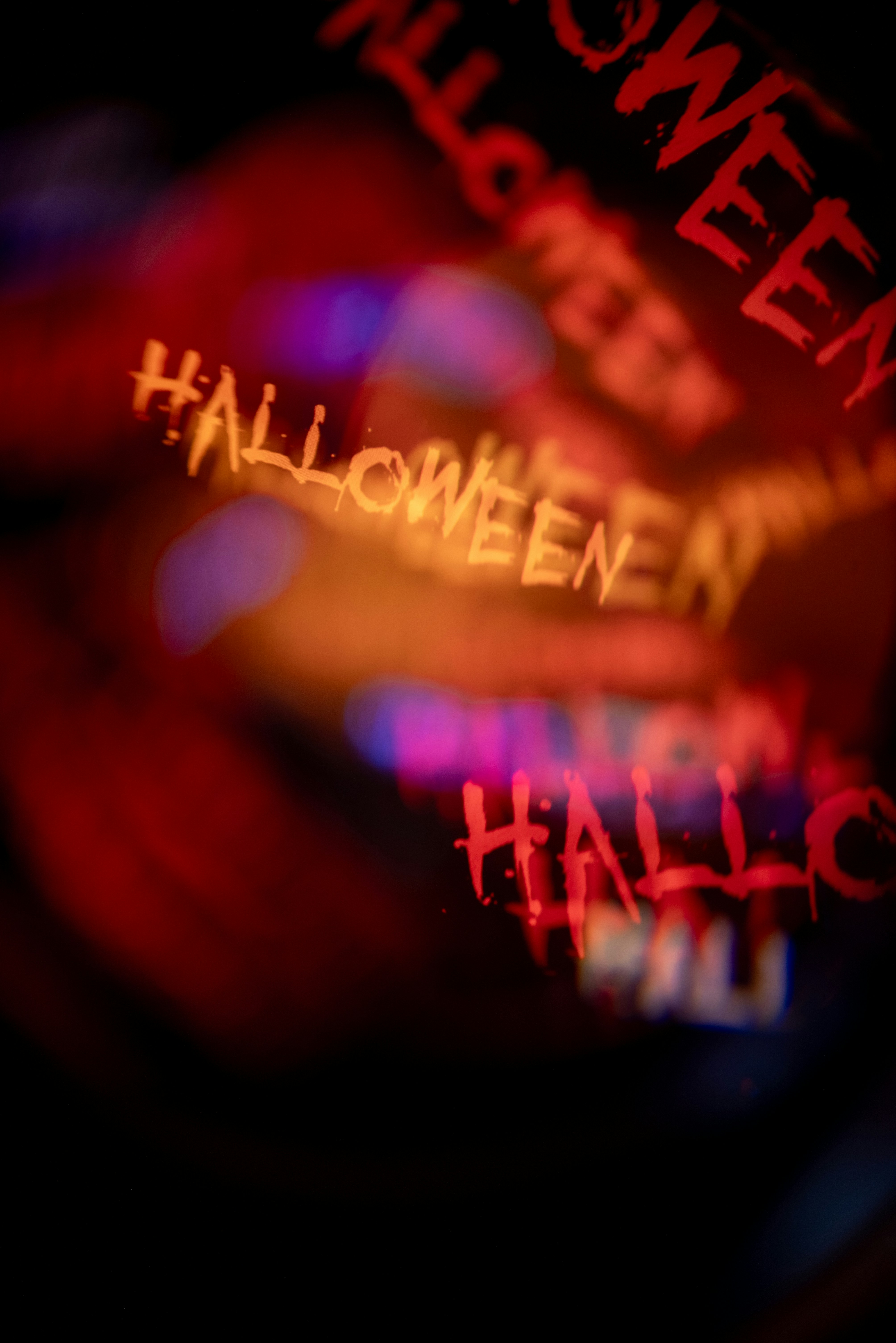 Texte flou rouge et orange disant Halloween sur fond sombre