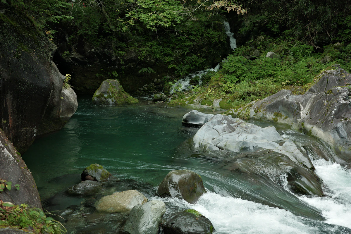 Río de aguas verdes entre grandes rocas