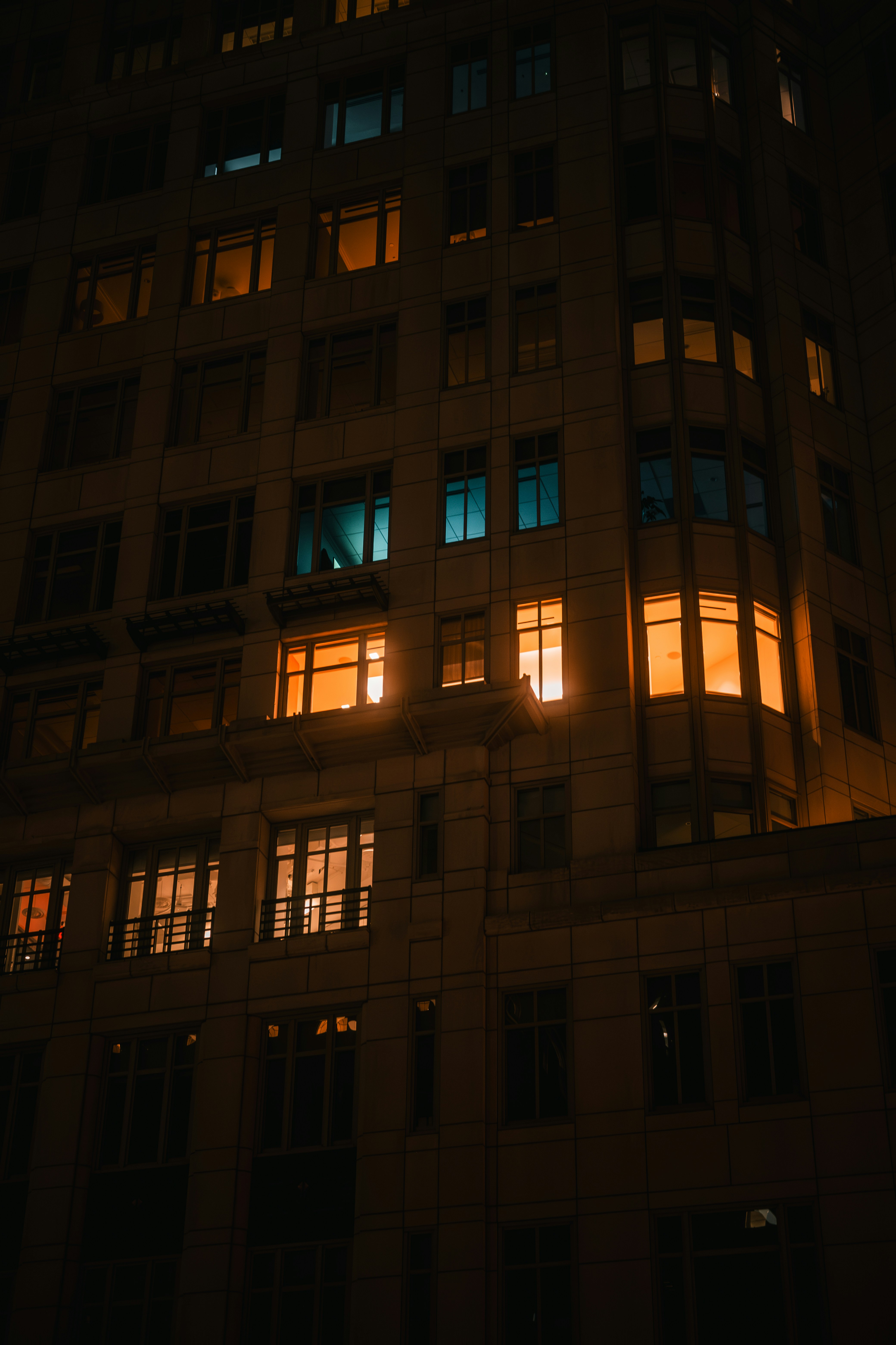 A stone building facade at night with glowing amber and teal windows in Washington