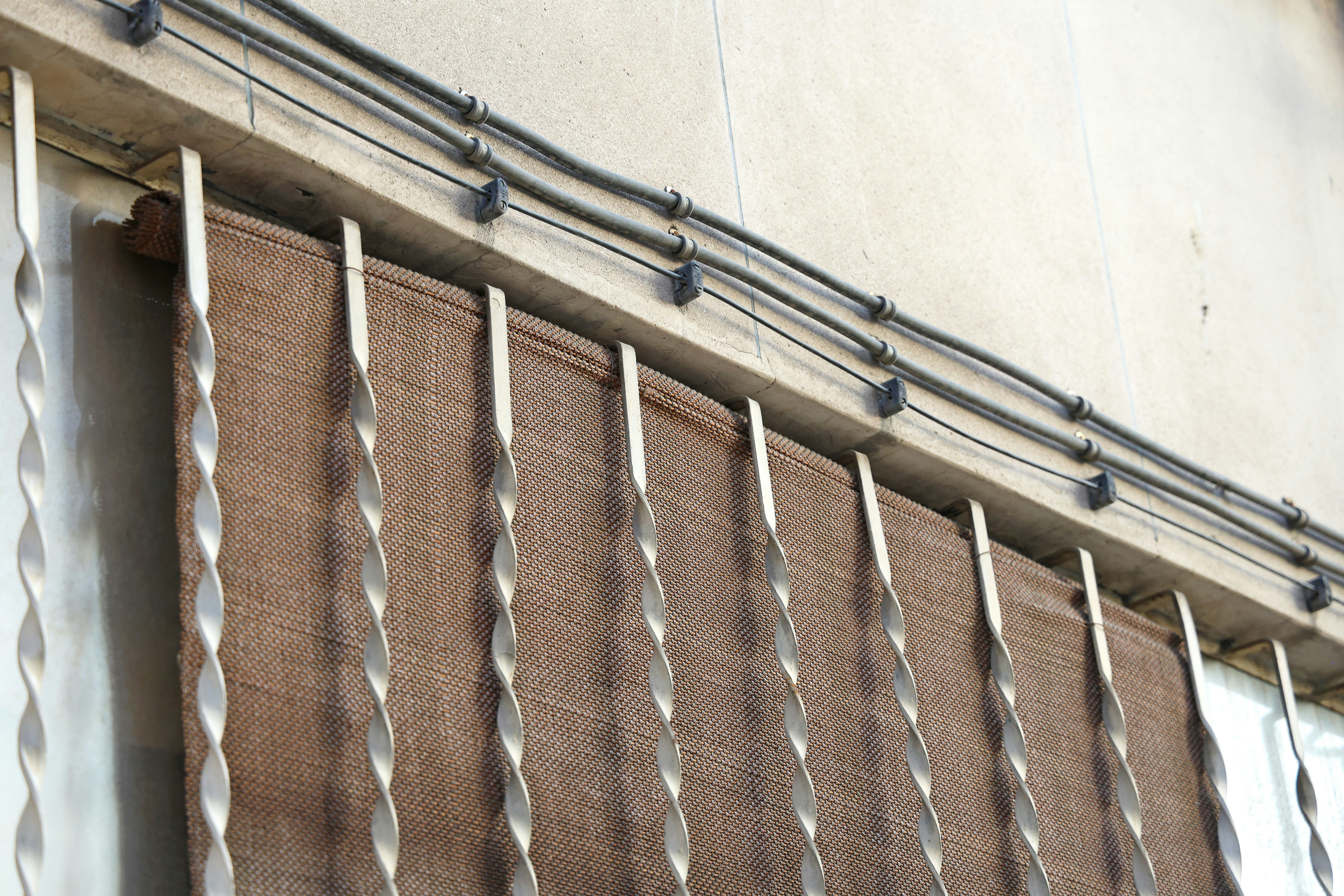 Brown sunshade behind twisted metal bars - Free Photo on Unsplash