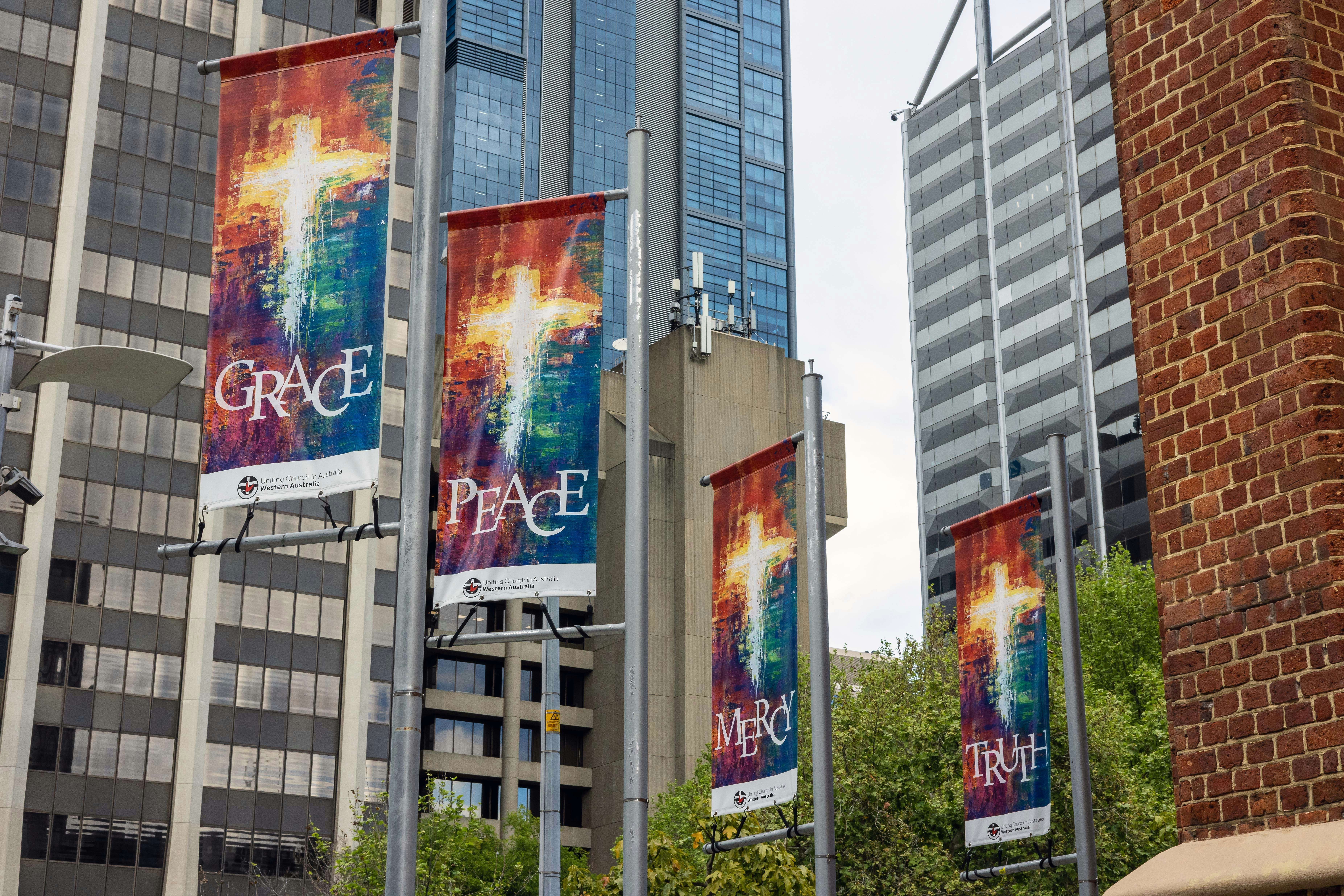 Four vertical banners with abstract cross designs and the words Grace, Peace, Mercy, and Truth in Perth