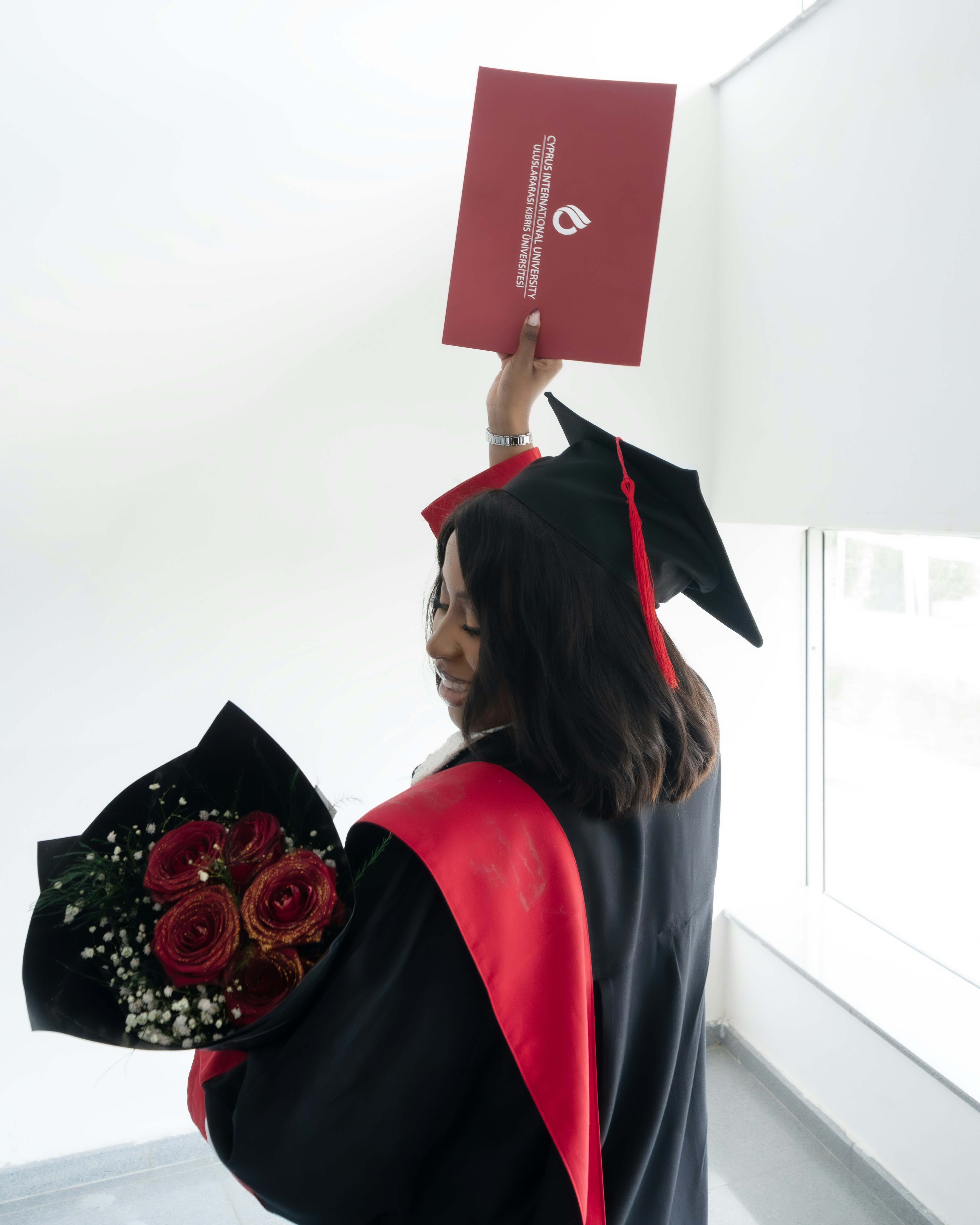 Graduate holding diploma and red roses - Free Photo on Unsplash