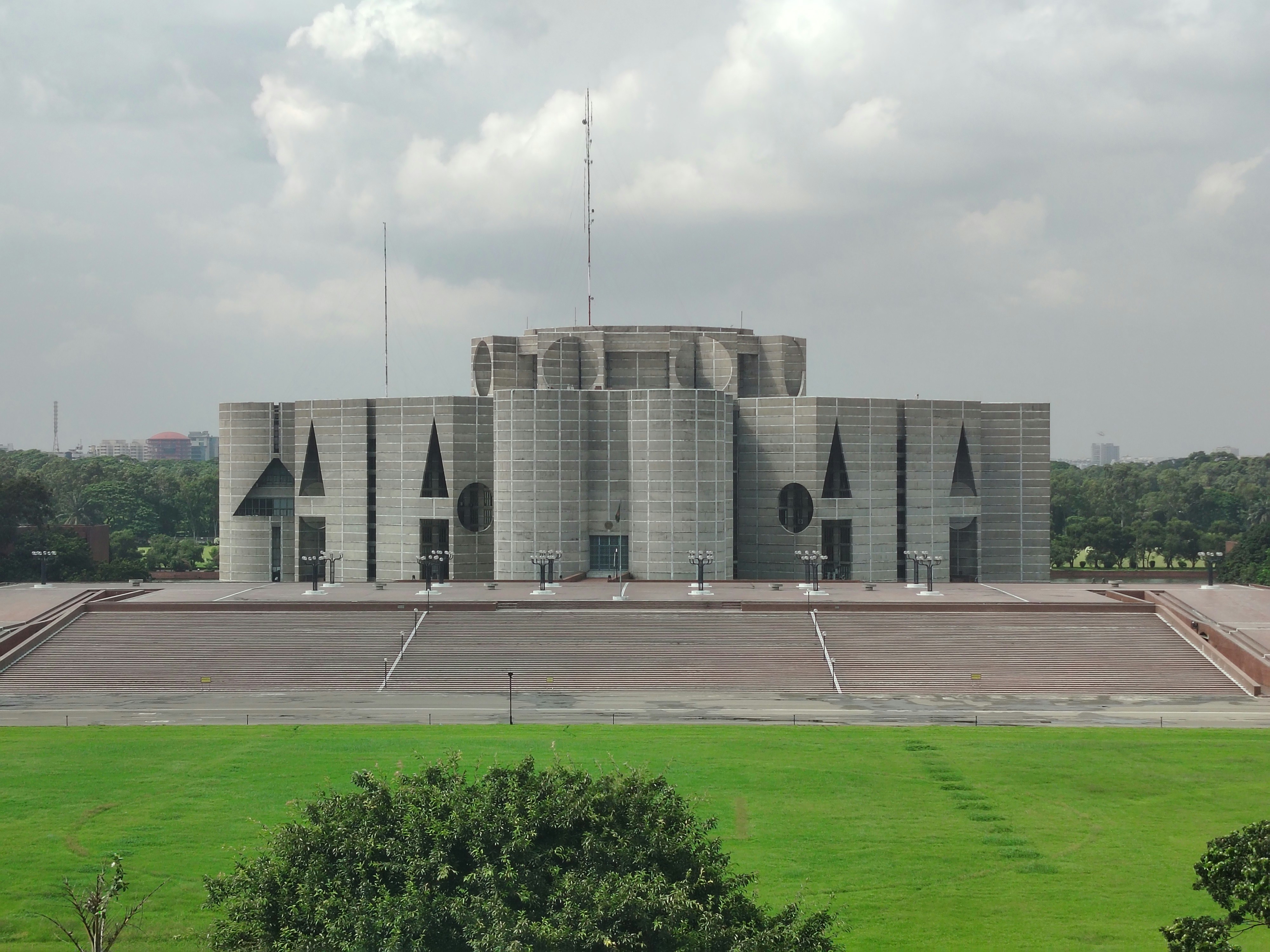 The Jatiya Sangsad Bhaban parliament building in Dhaka with a large green lawn and stone steps