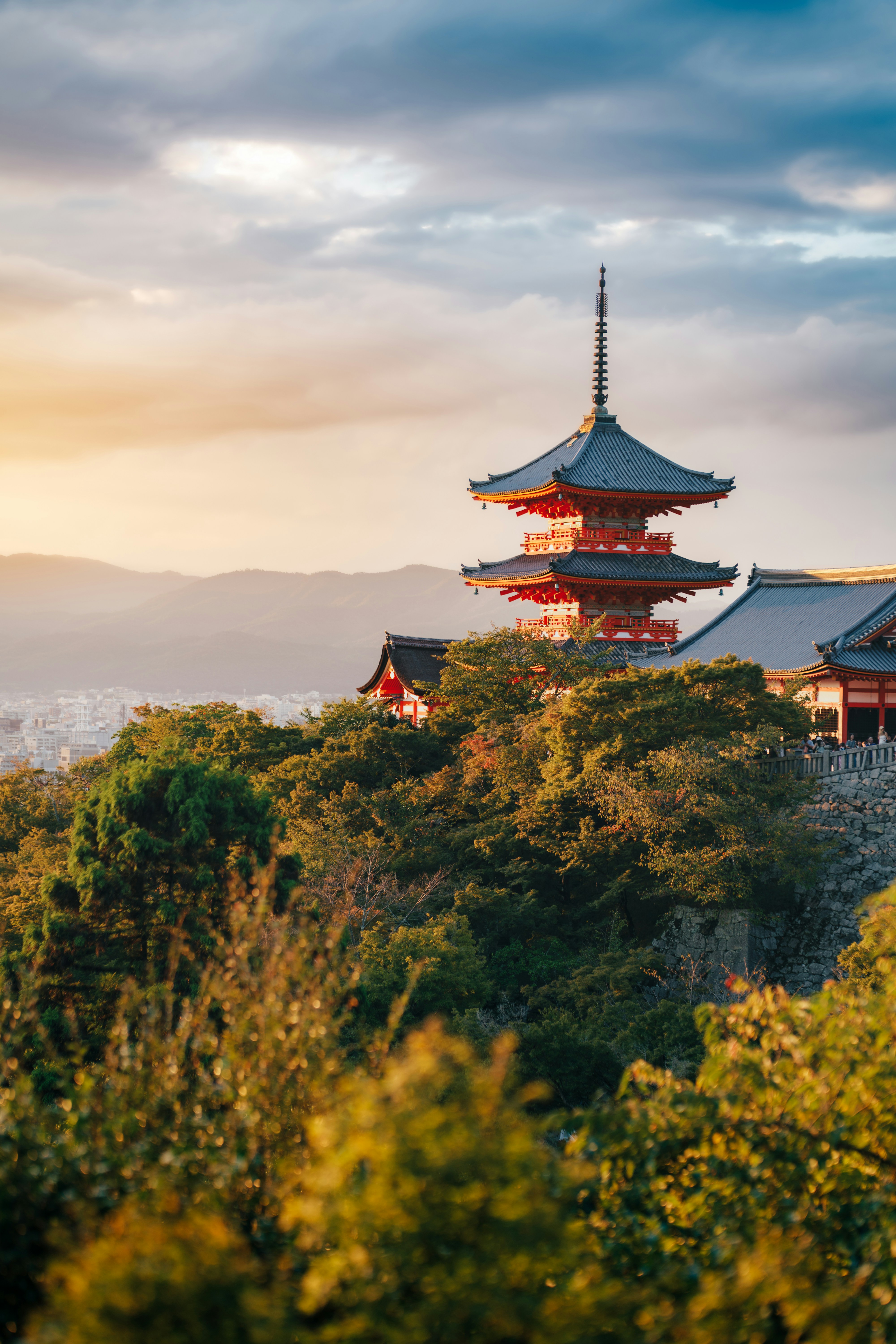 The Kiyomizu-dera temple pagoda rising above lush trees in Kyoto at golden hour