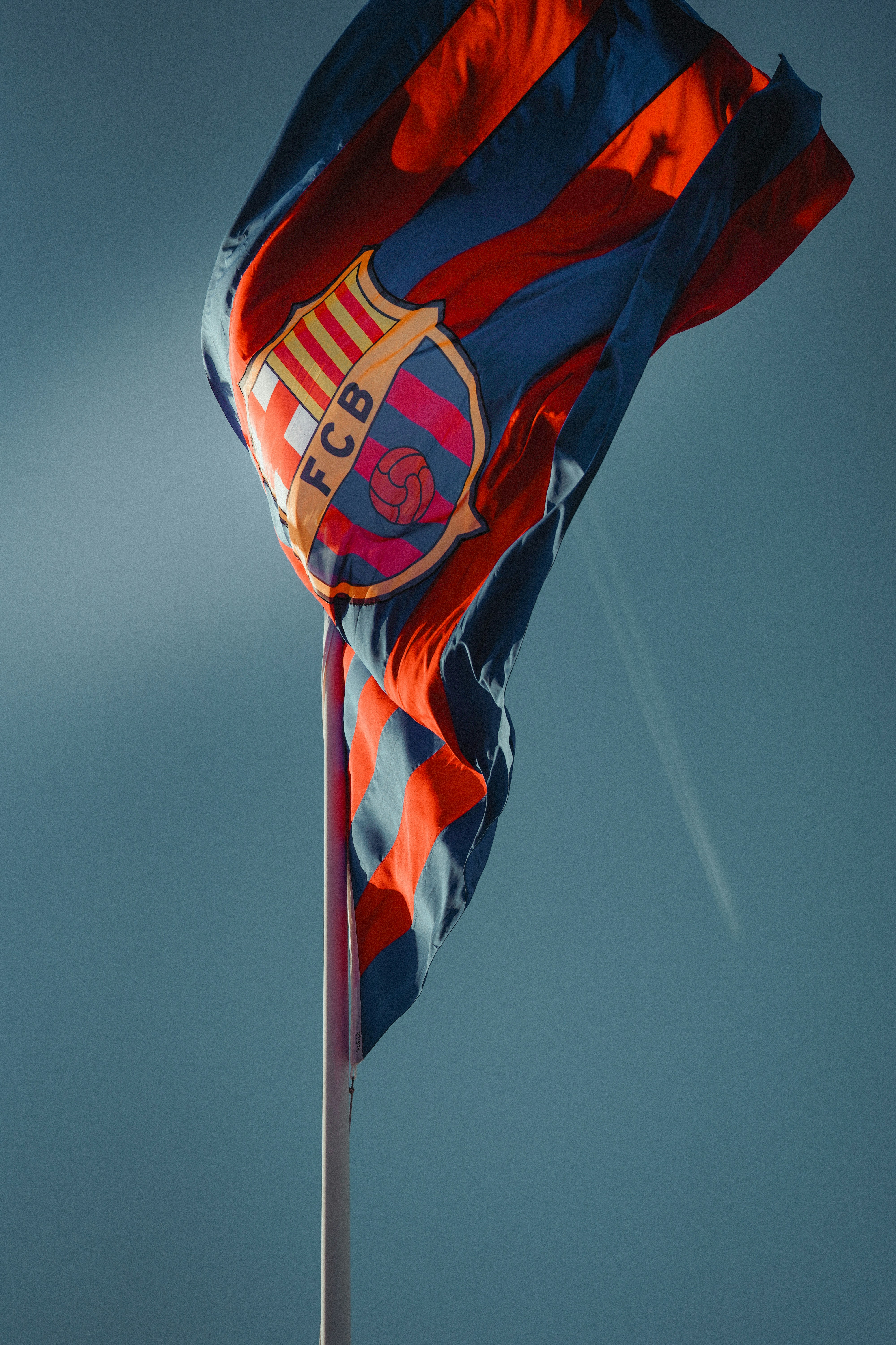 The FC Barcelona flag waving against a clear blue sky