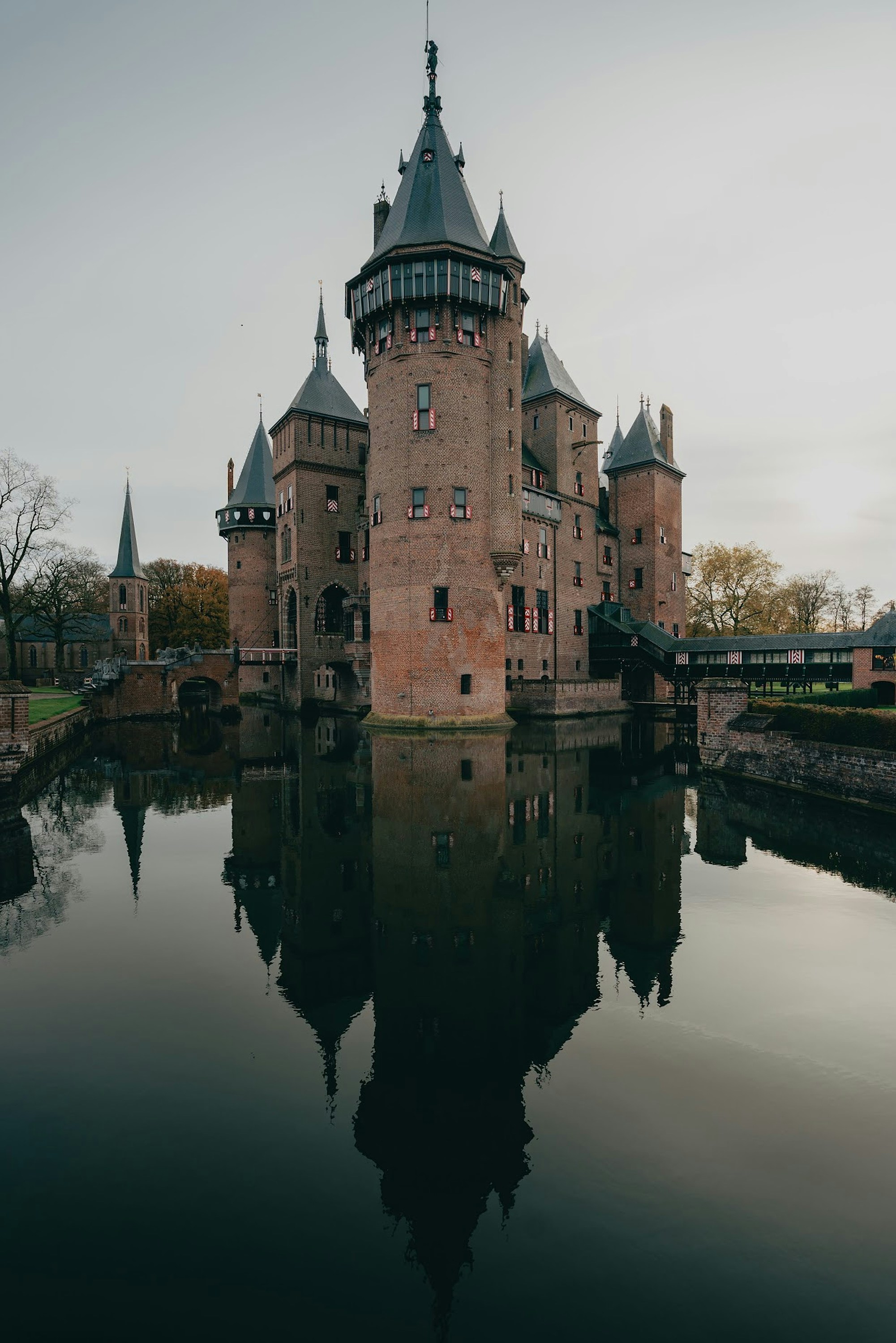 De Haar Castle with its reflection in the surrounding moat under a grey sky