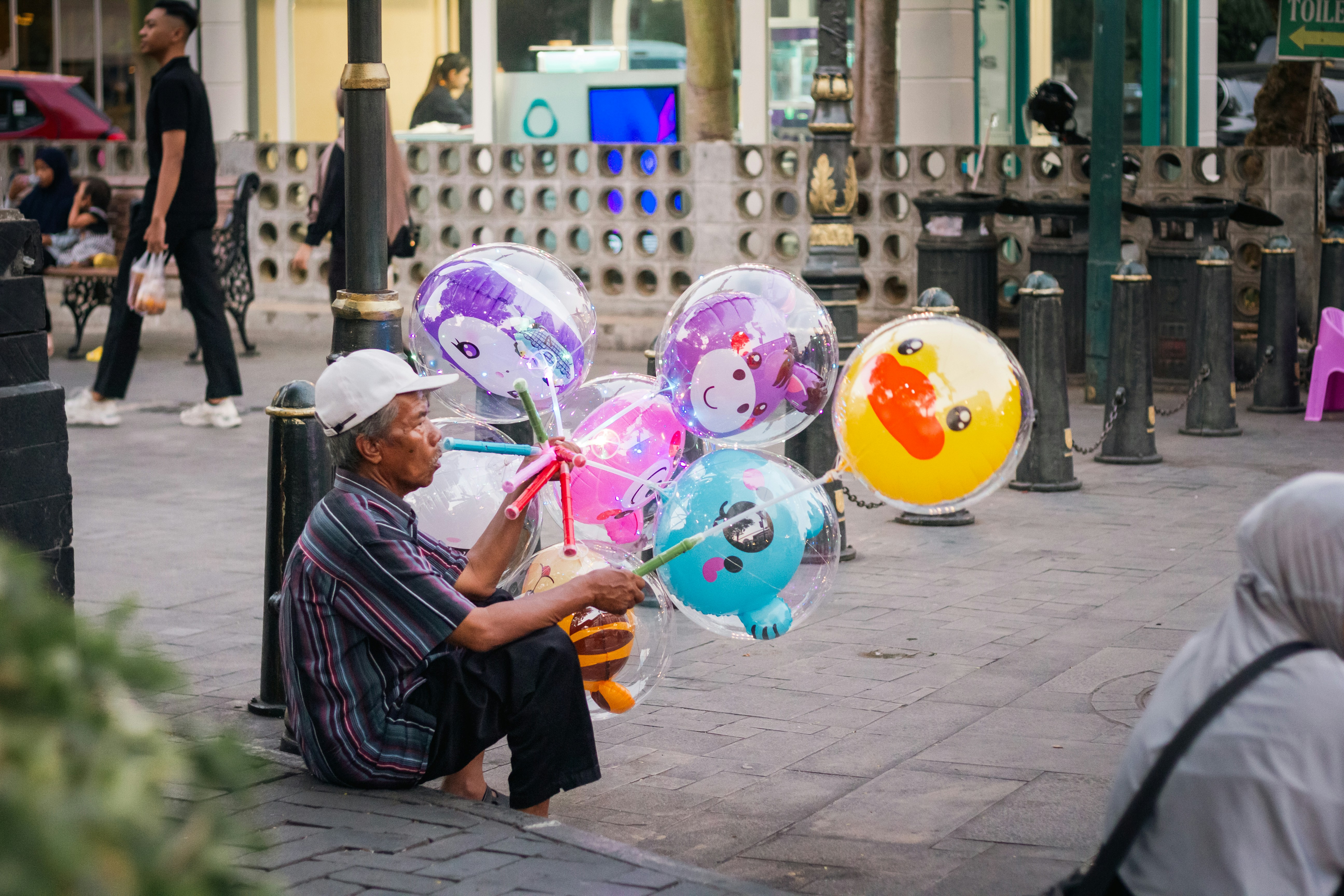 Man inflating balloons on city sidewalk - Free Photo on Unsplash