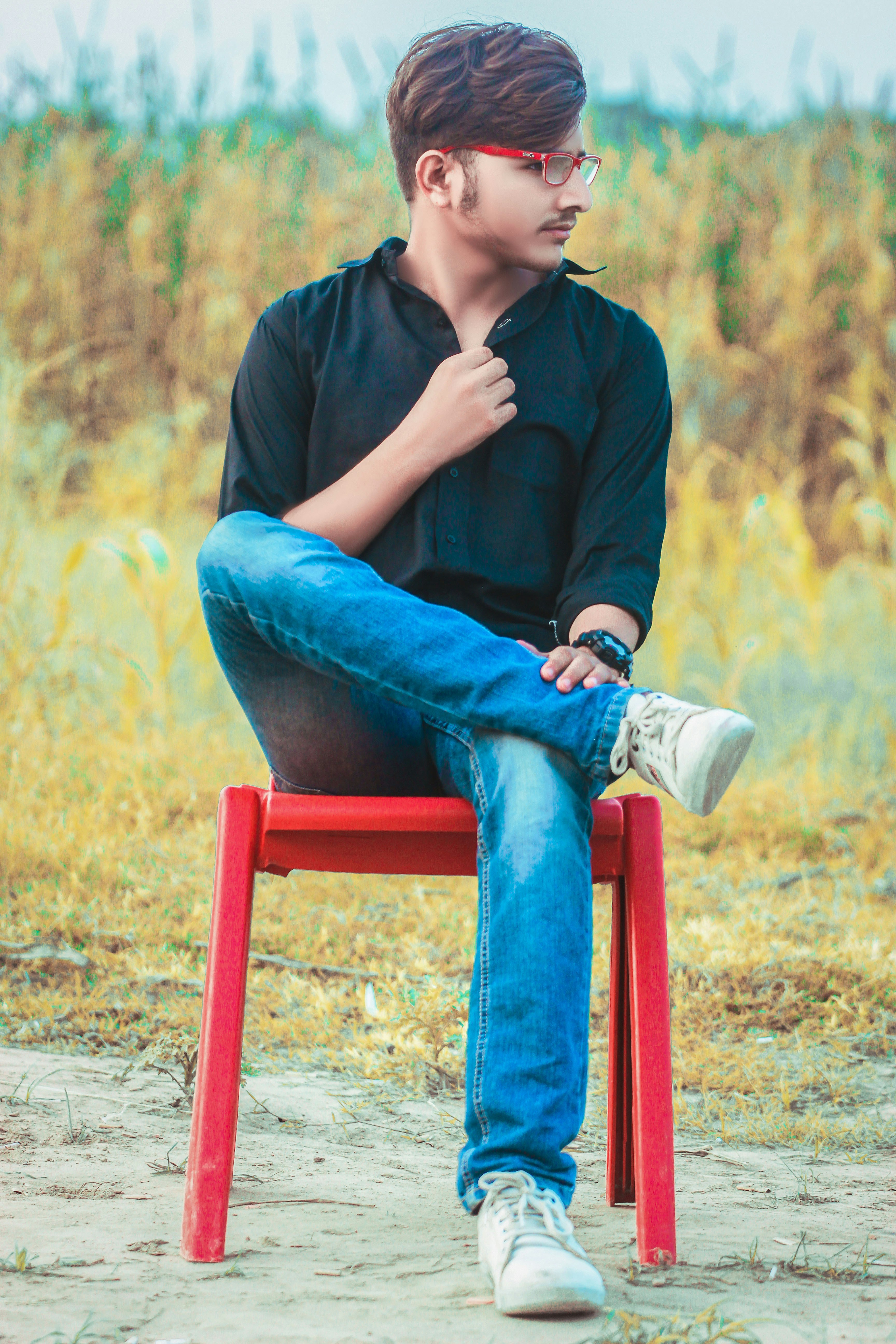 Young man sitting on red chair - Free Photo on Unsplash