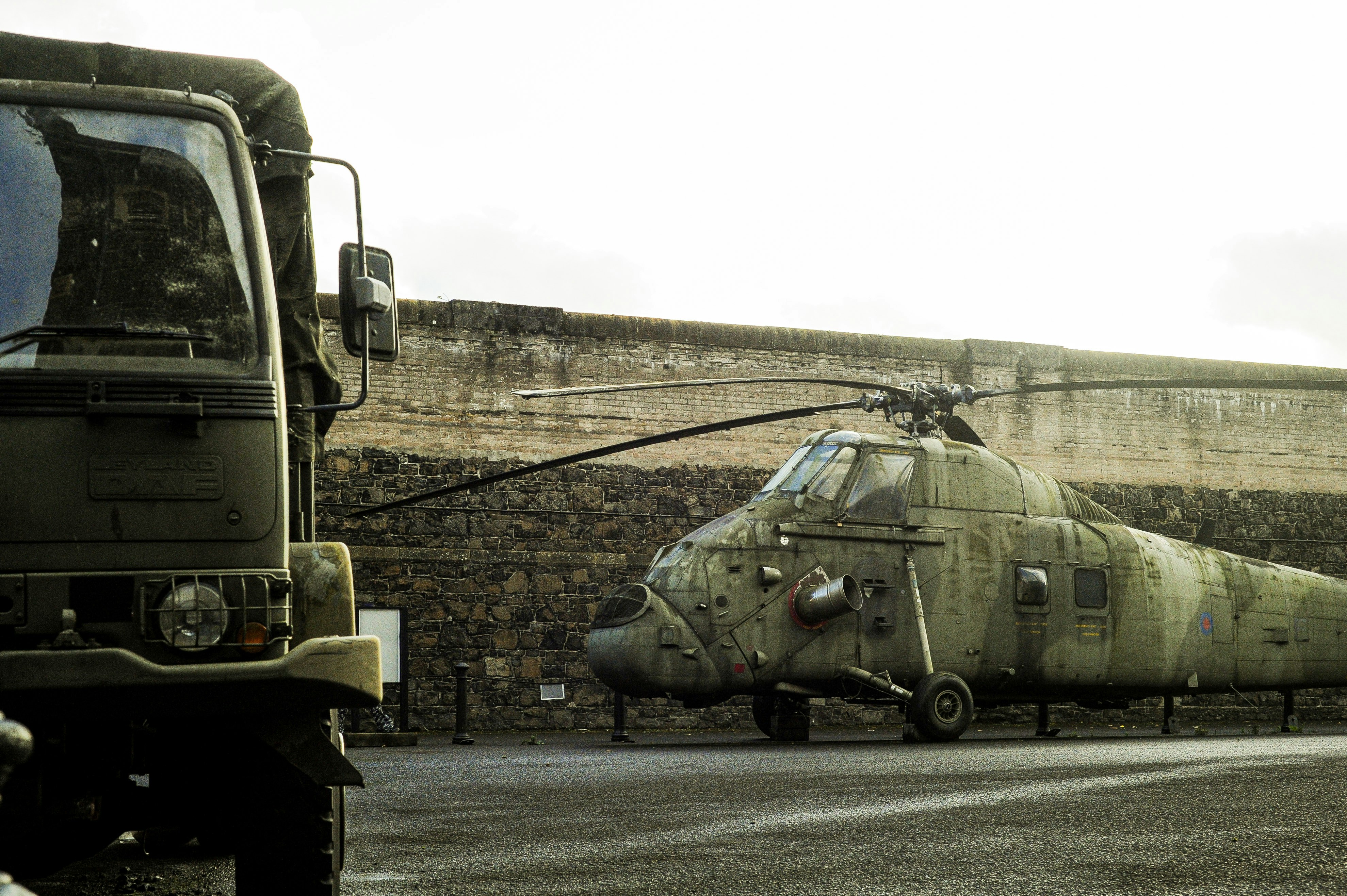 Military helicopter and truck by wall - Free Photo on Unsplash
