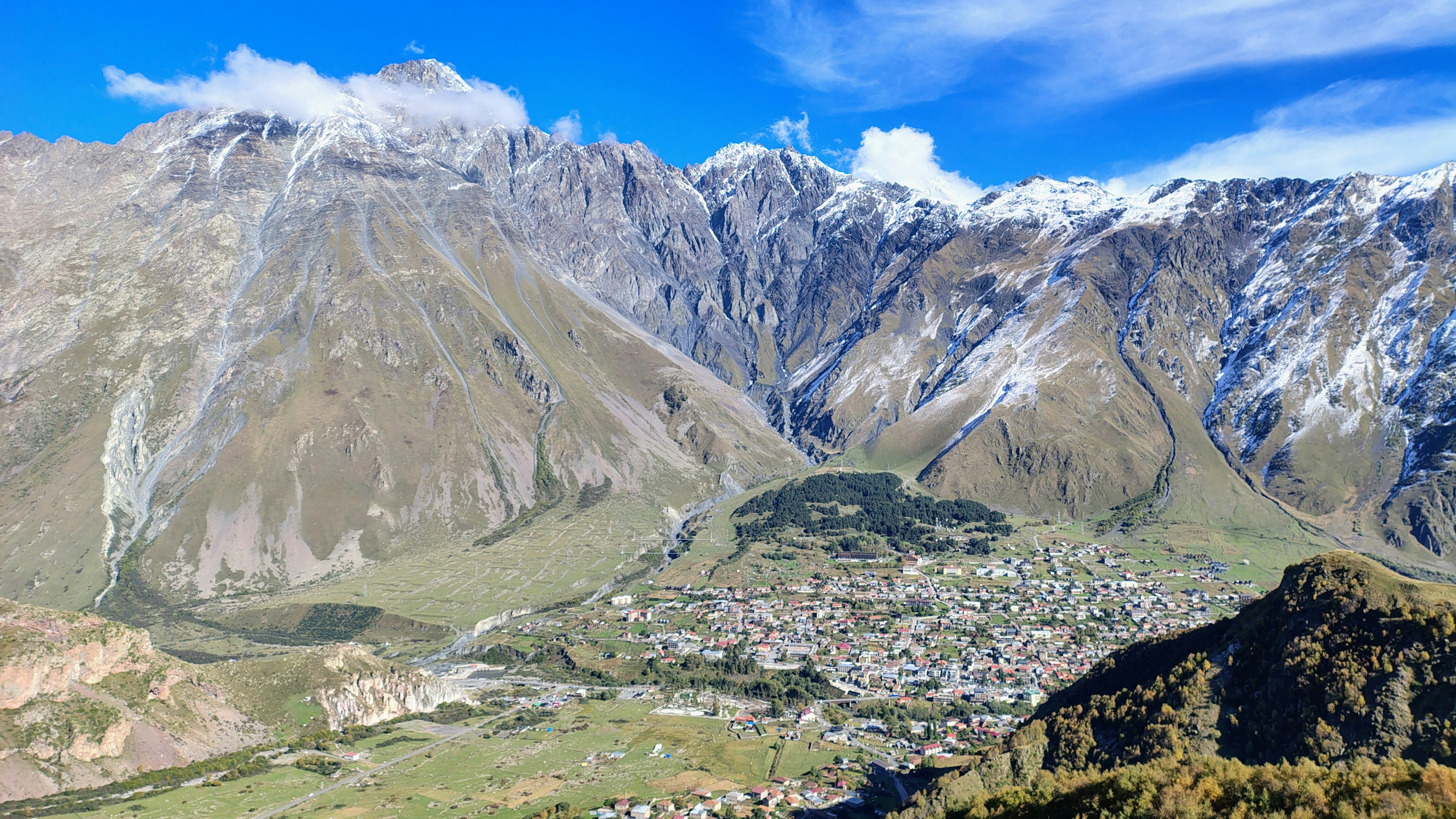 Town in valley below snow-capped mountains - Free Photo on Unsplash