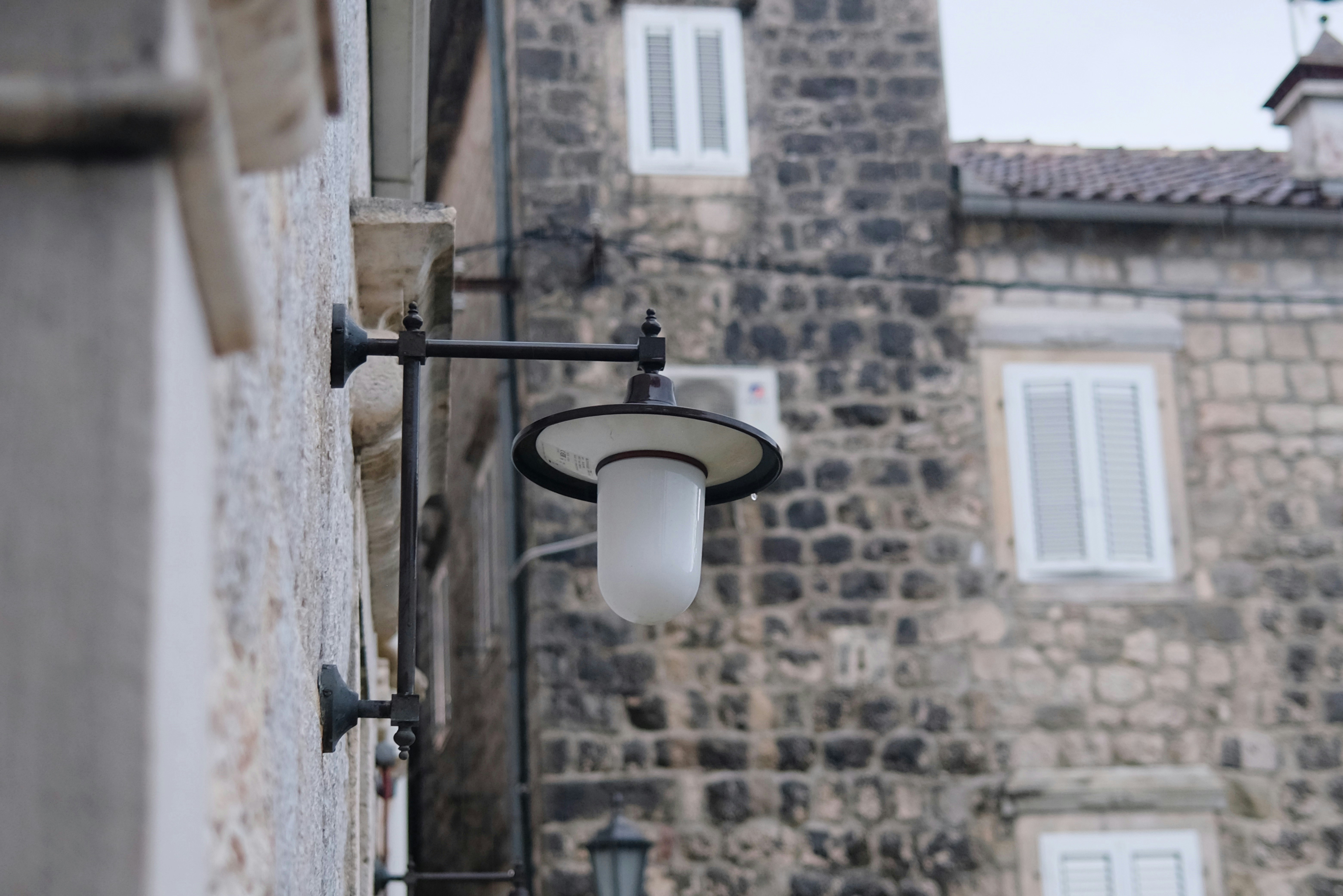 Wall lamp on stone building - Free Photo on Unsplash