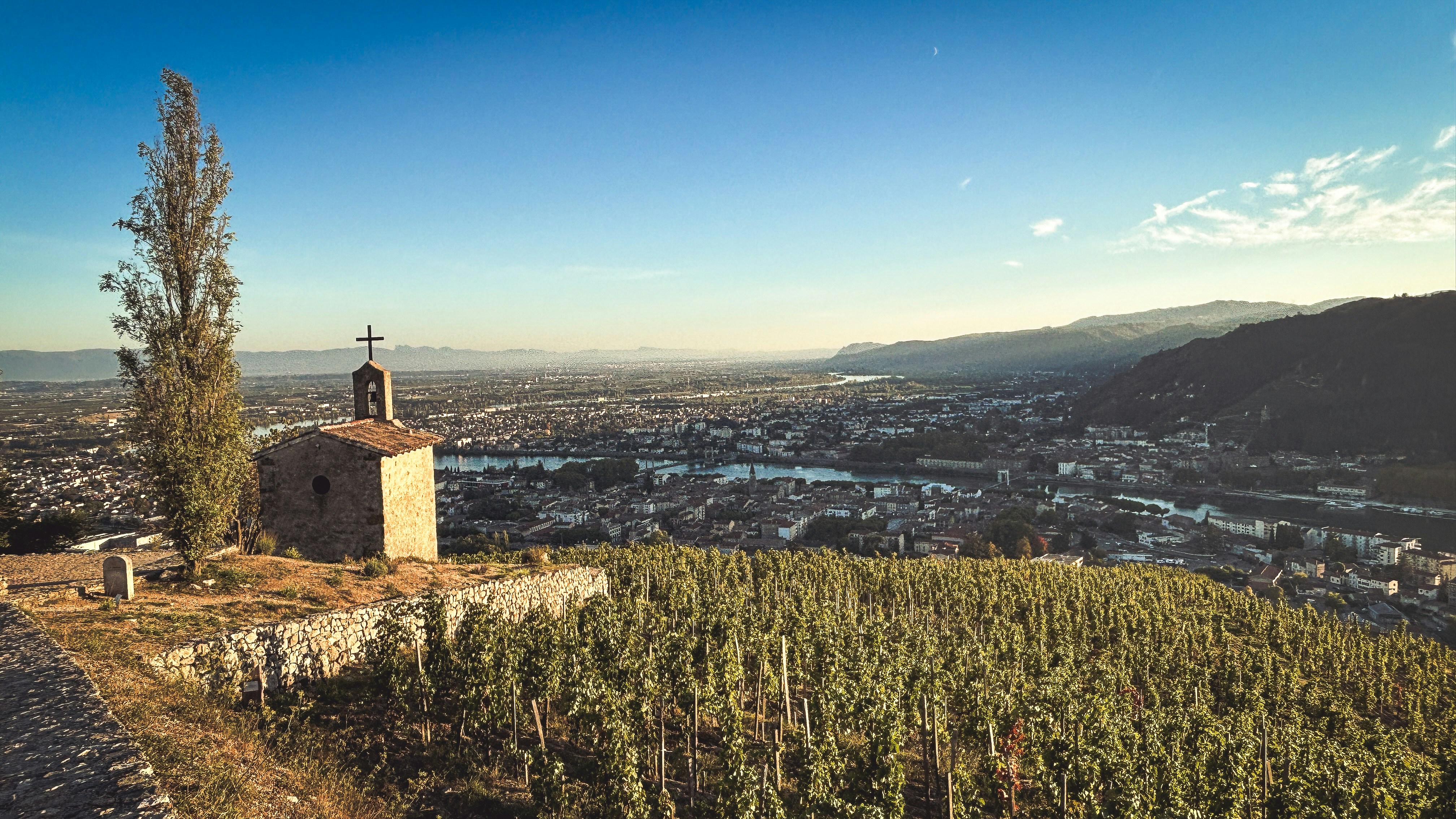 Stone chapel overlooking river valley town - Free Photo on Unsplash