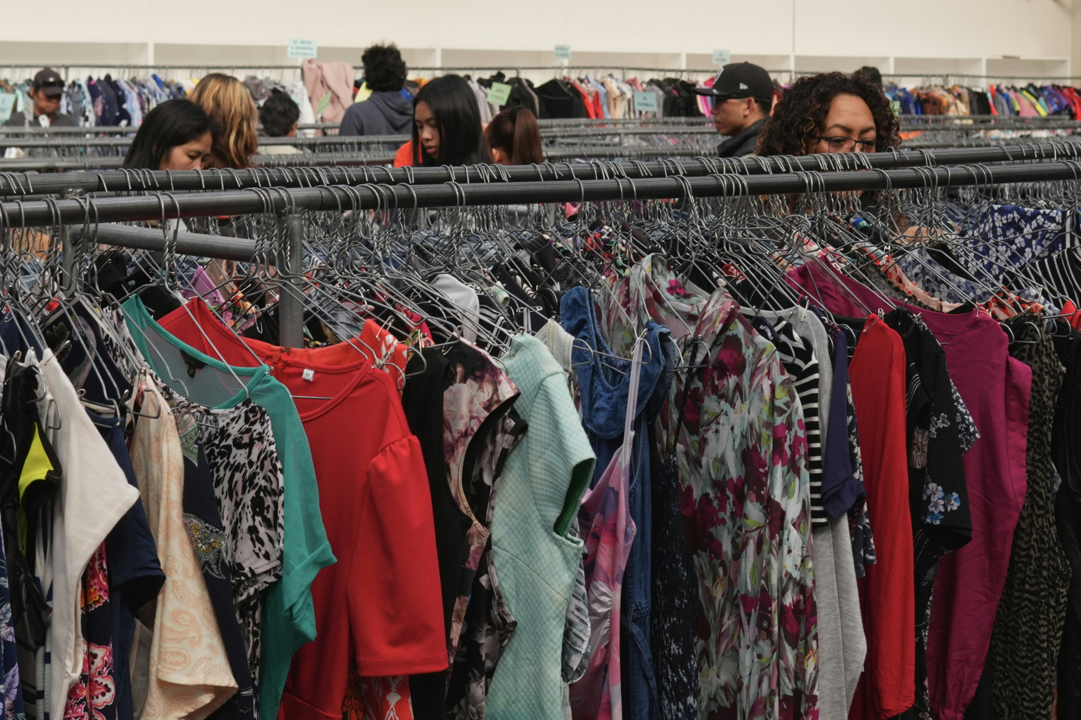 People browsing clothing in thrift store - Free Photo on Unsplash