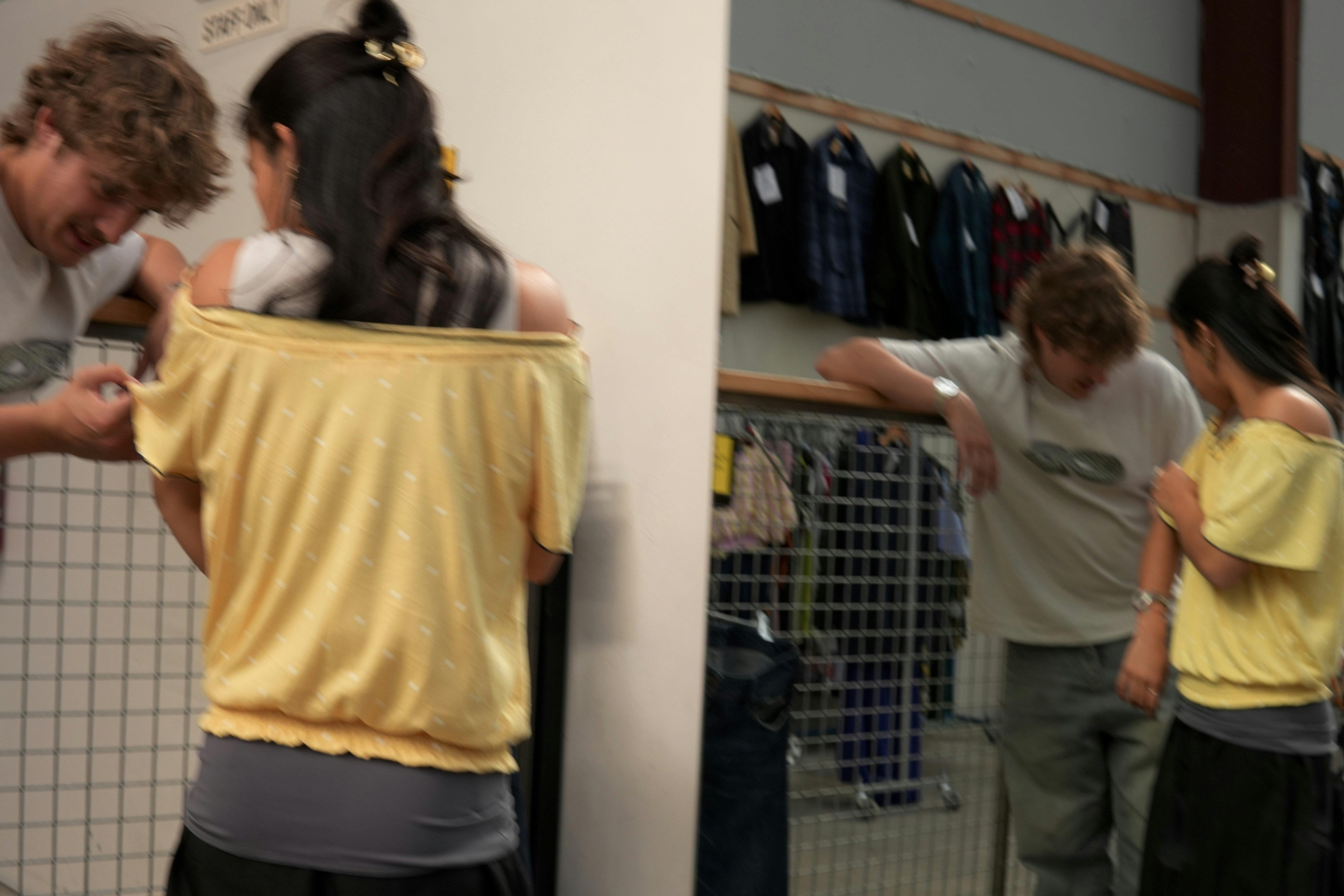 Two people in a clothing with a man and a woman looking at garments