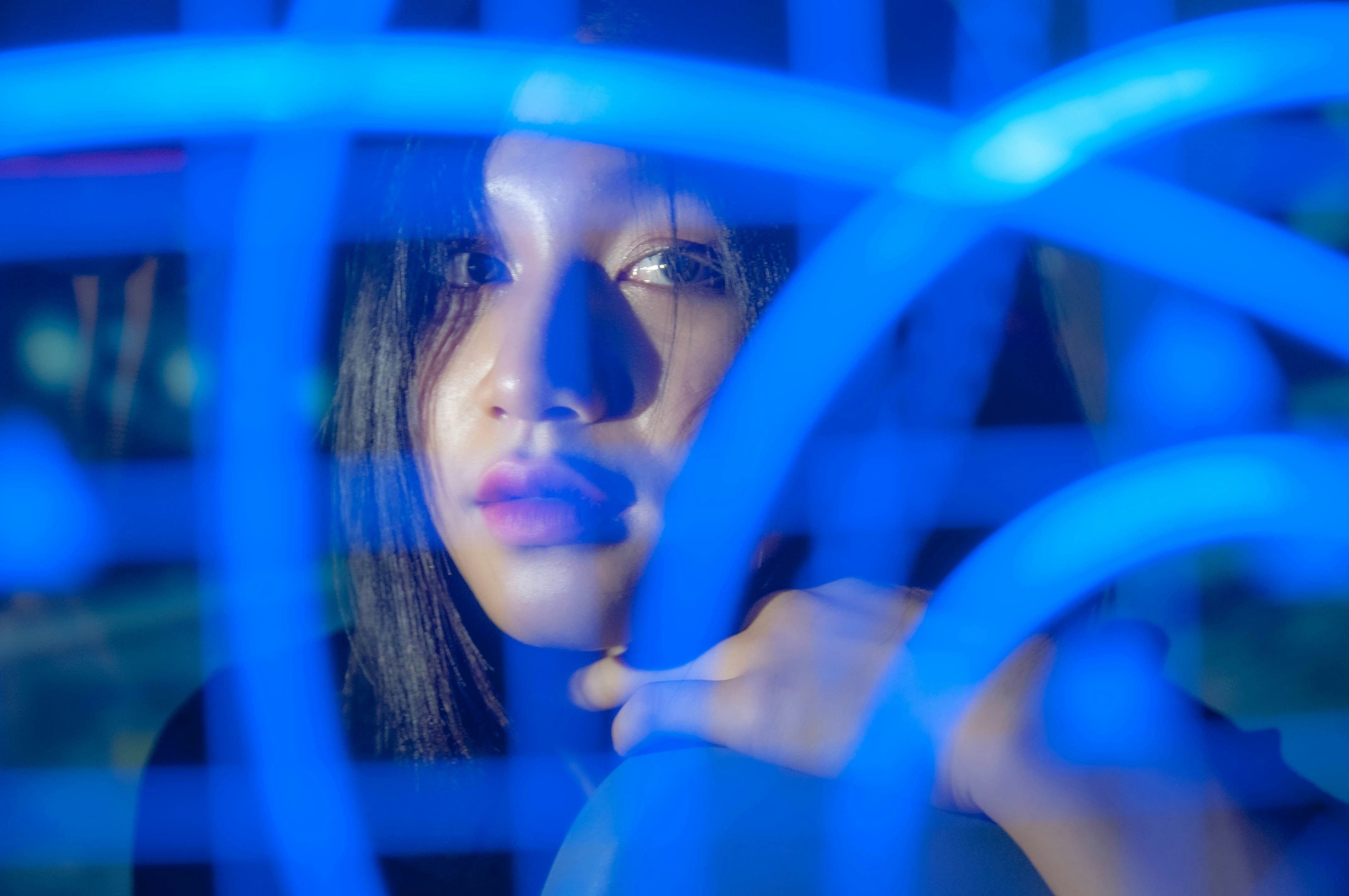 Woman behind blue neon light tubes - Free Photo on Unsplash